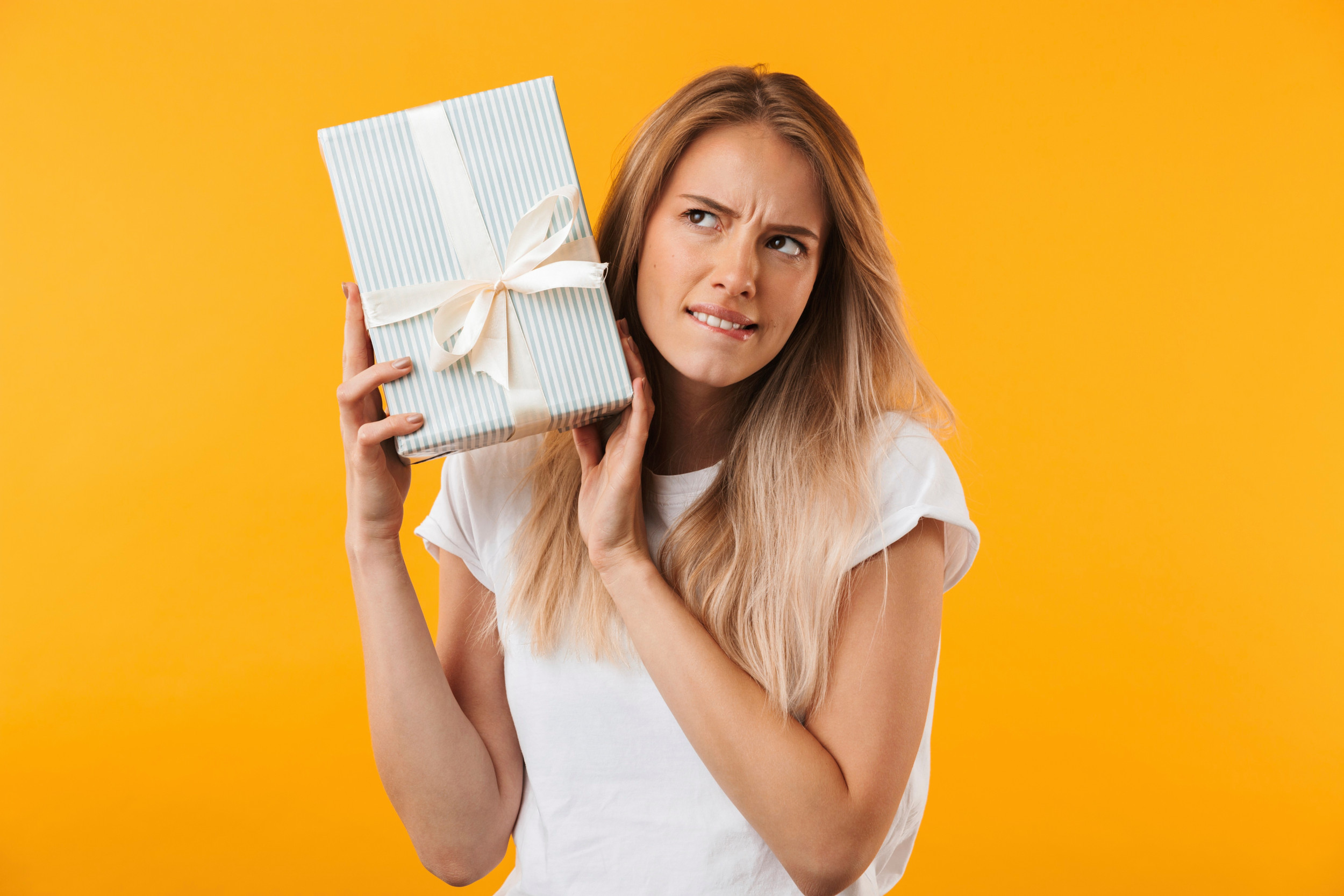 Ung kvinde ser mistroisk på en pakke.