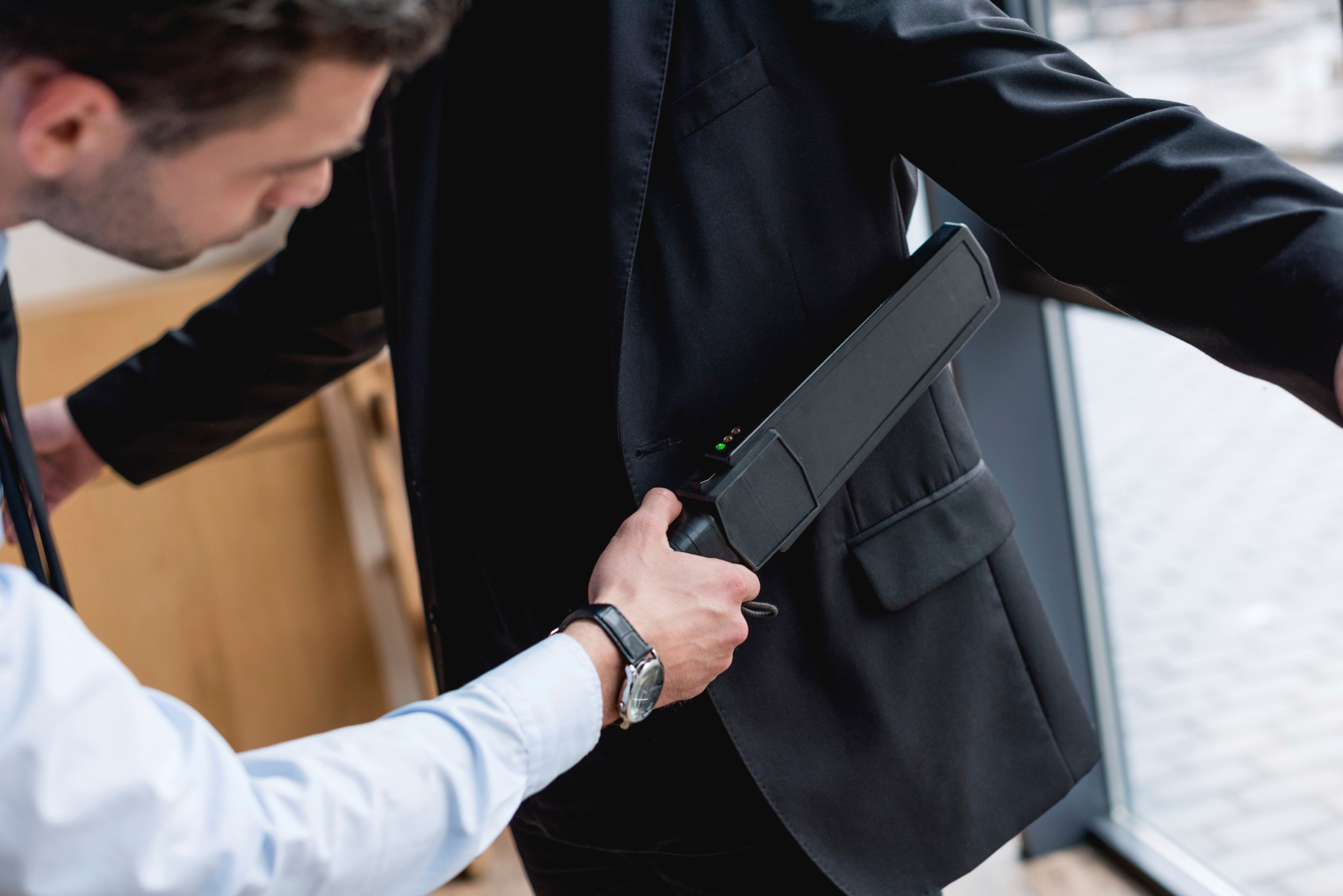 Sikkerhedsvagt scanner mand på vej ind i retten.