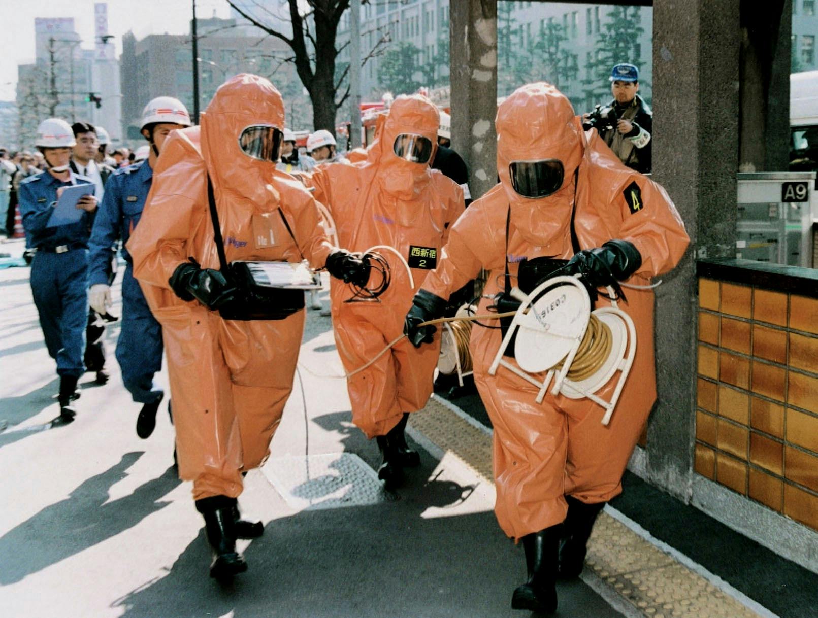 En gruppe fra Tokyos brandvæsen i beskyttelsesdragter nær ved Kasumigaseki Stationen den 20. marts 1995 efter gasangrebet.