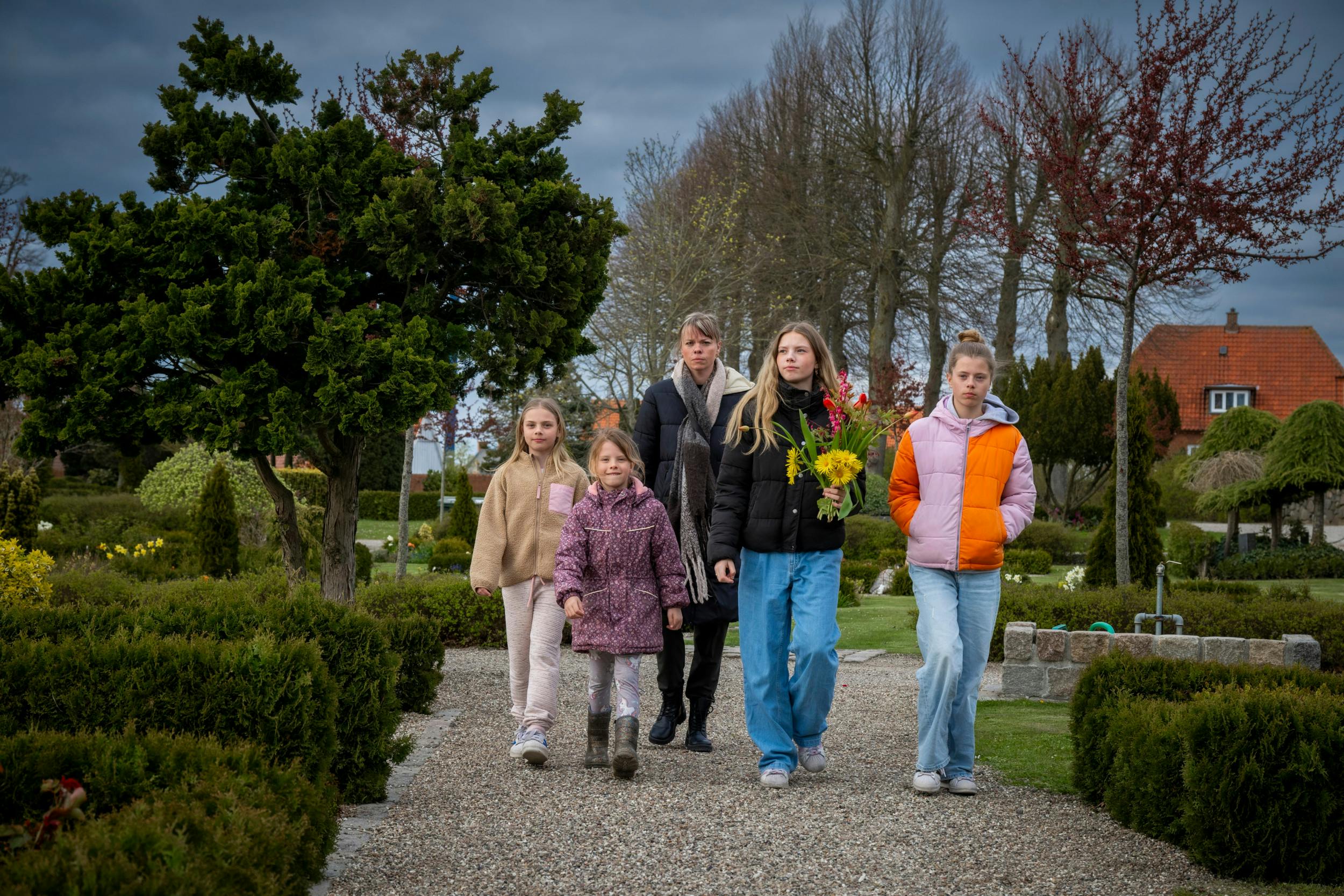 Julie går på kirkegården med sine døtre