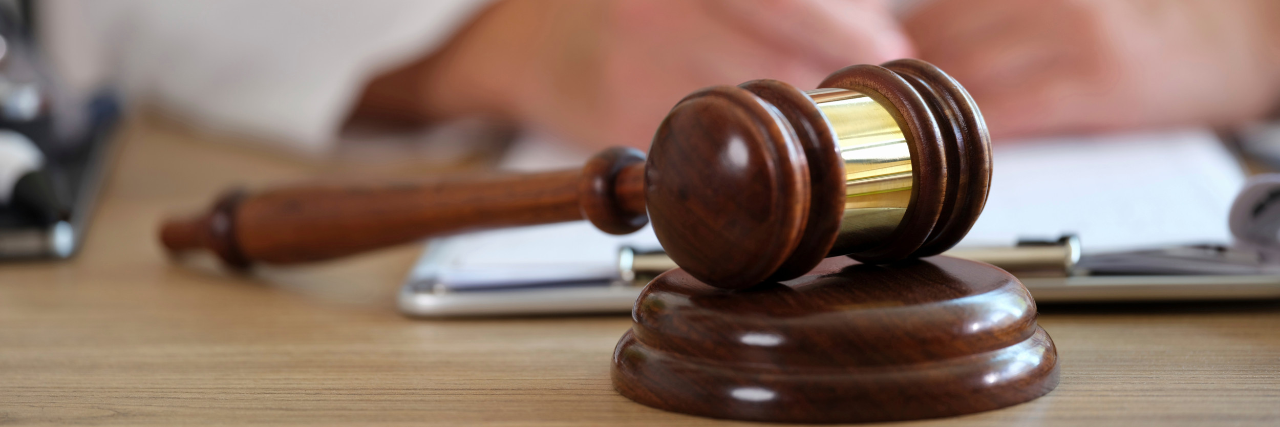 Dommerhammer ligger på et bord foran nogle papirer.