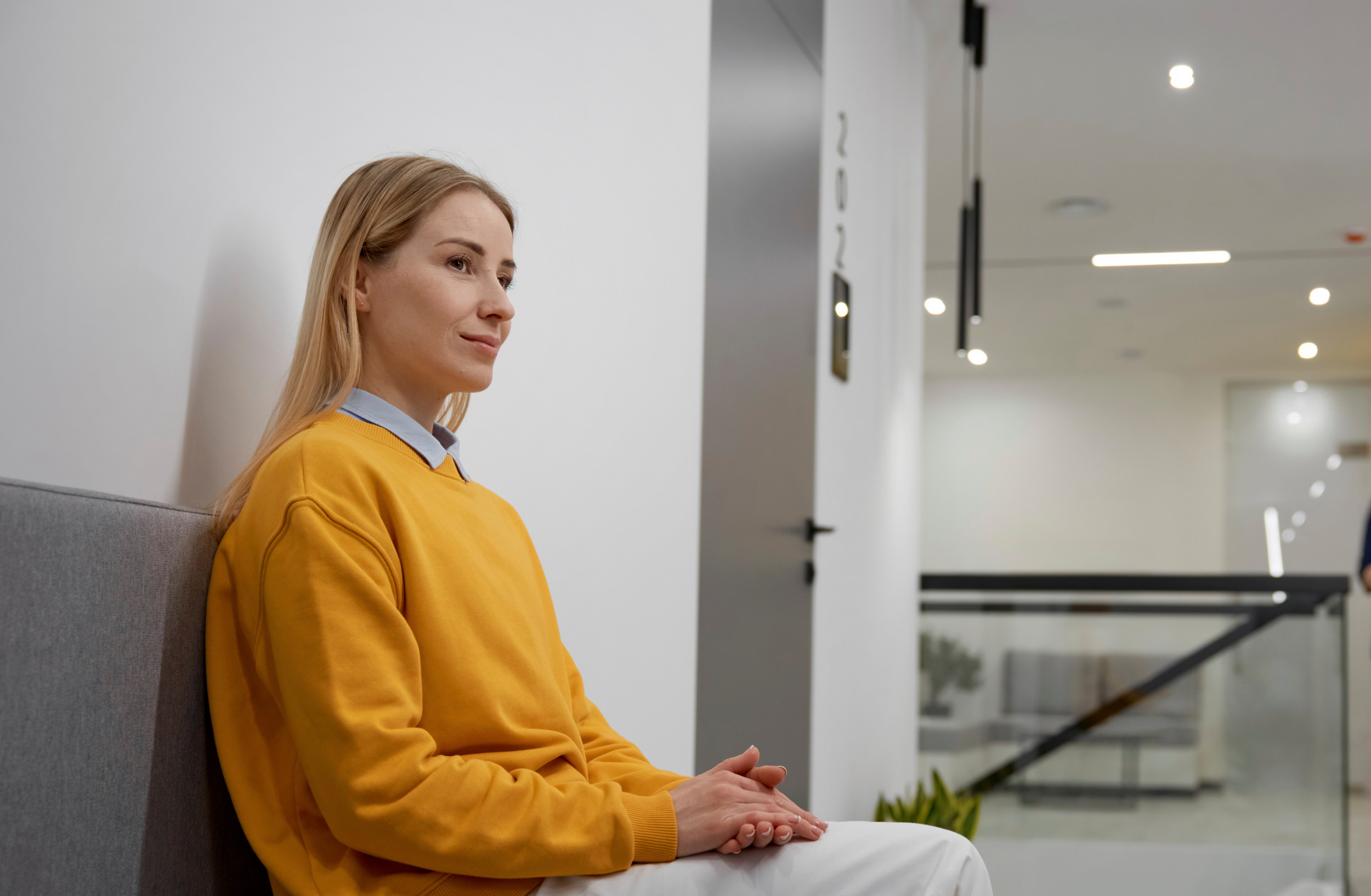 Ung kvinde sidder og venter udenfor et retslokale.