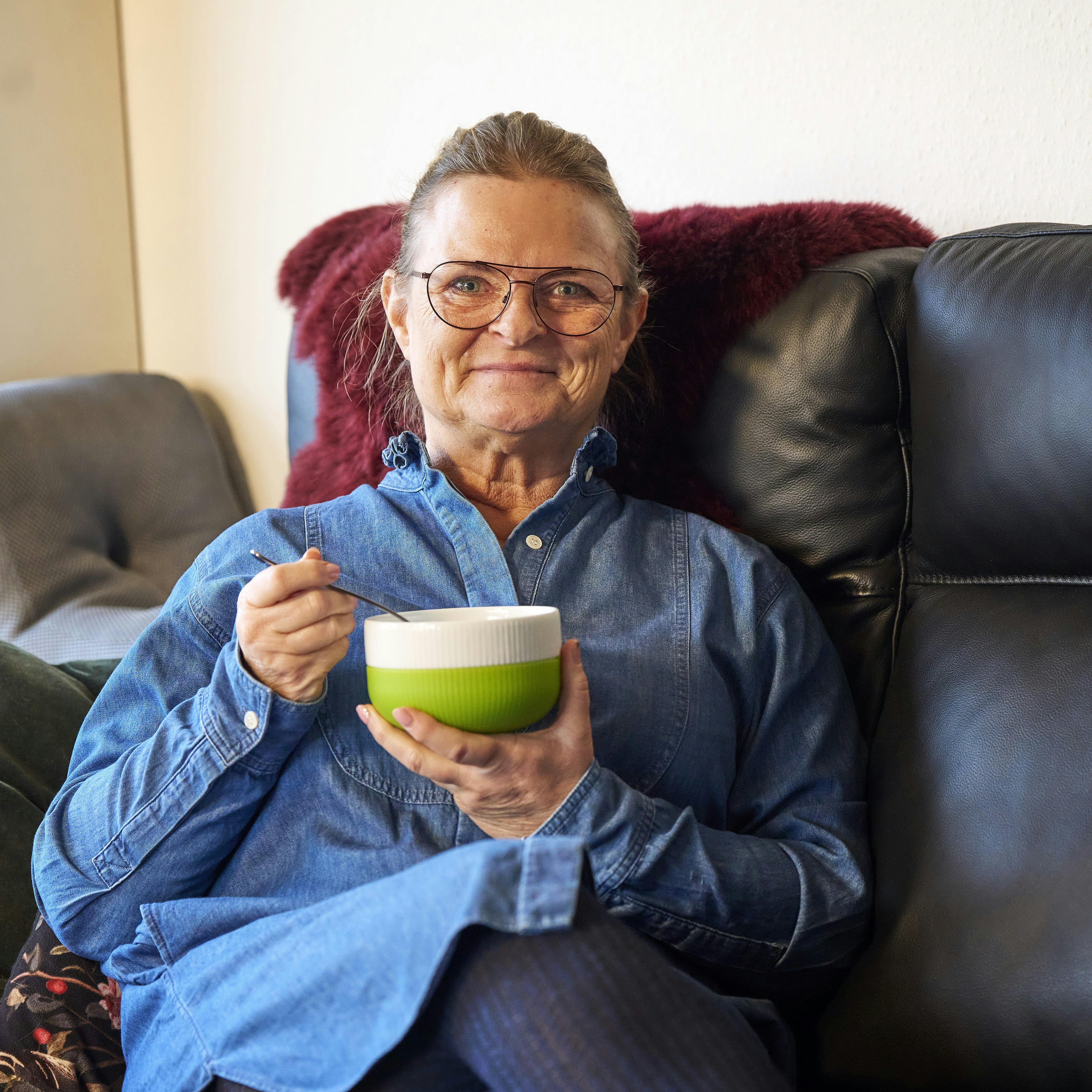 Turi Mørkøre Berg nyder en skål suppe i sin sofa.