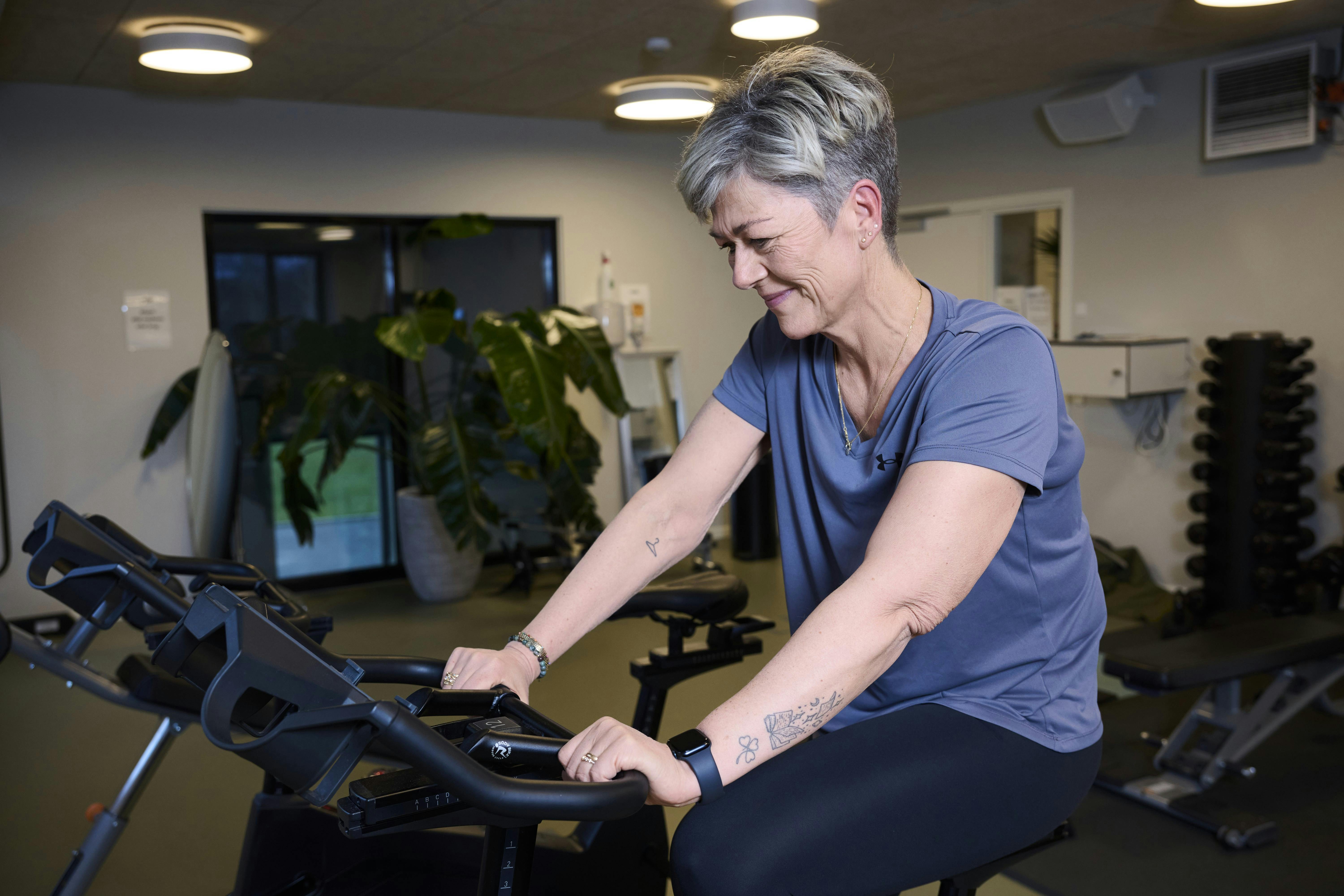 Carina Baag Andersen træner på en kondicykel.