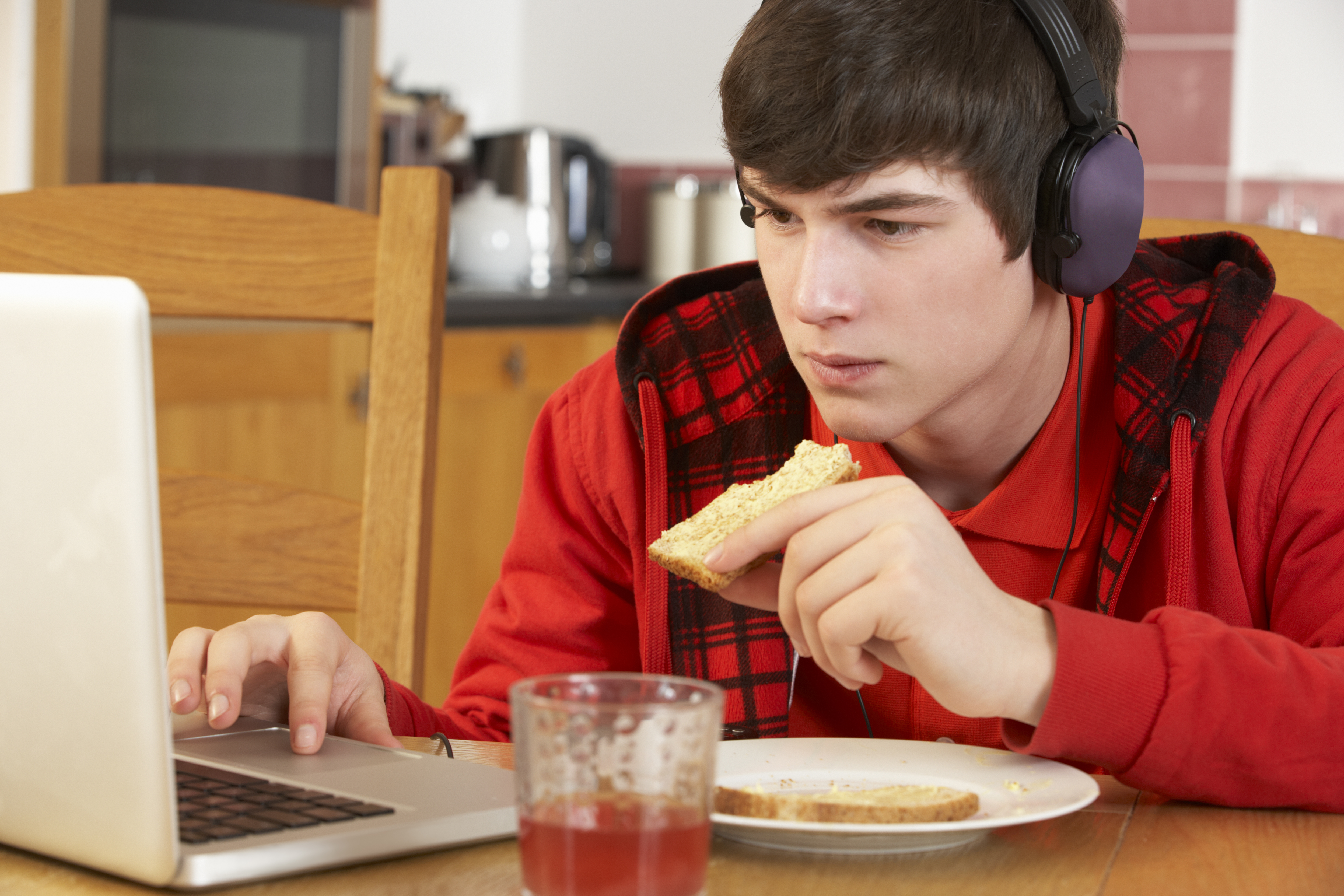 Teenager spiser foran computer
