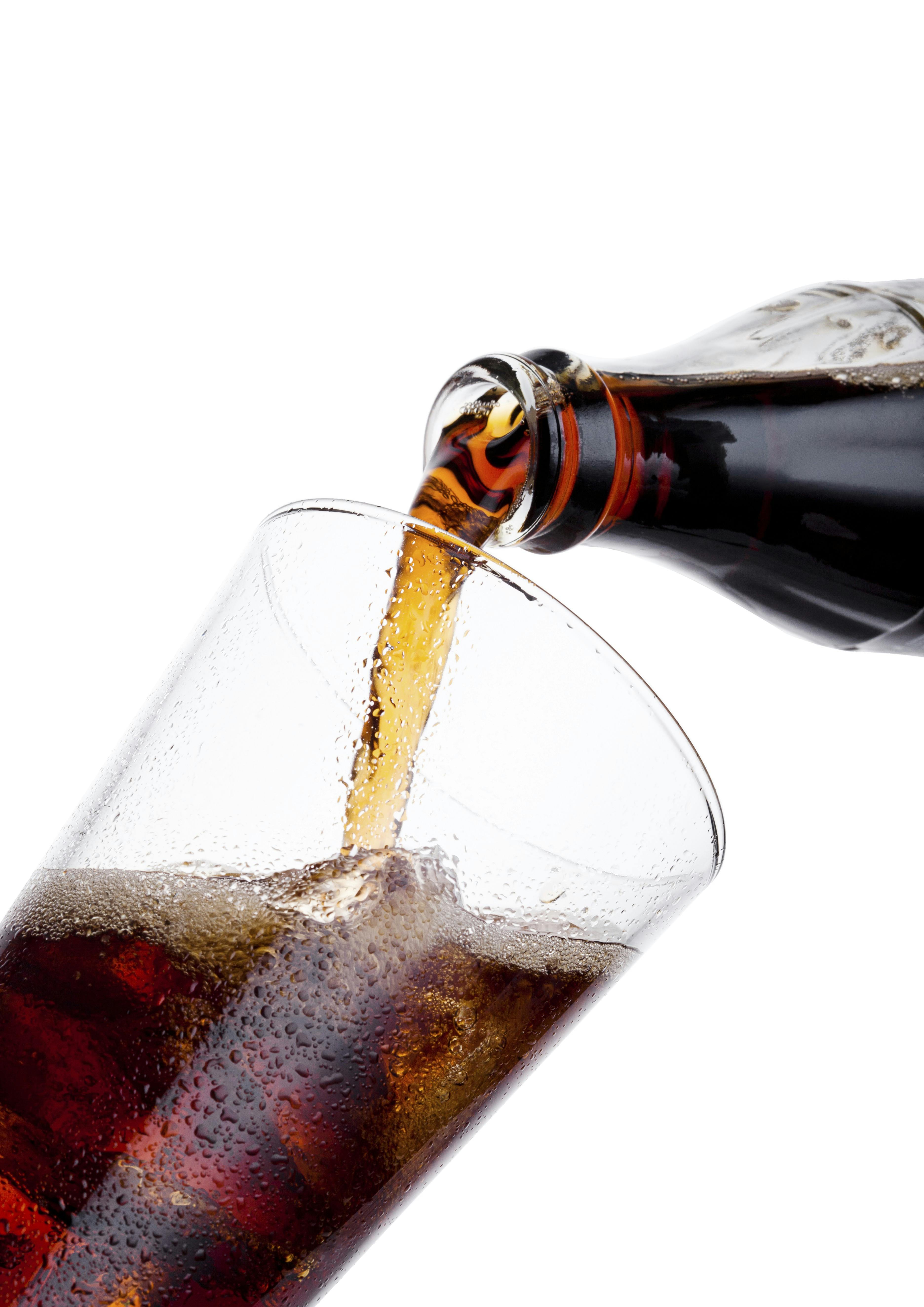 Cola bliver hældt op i et glas.