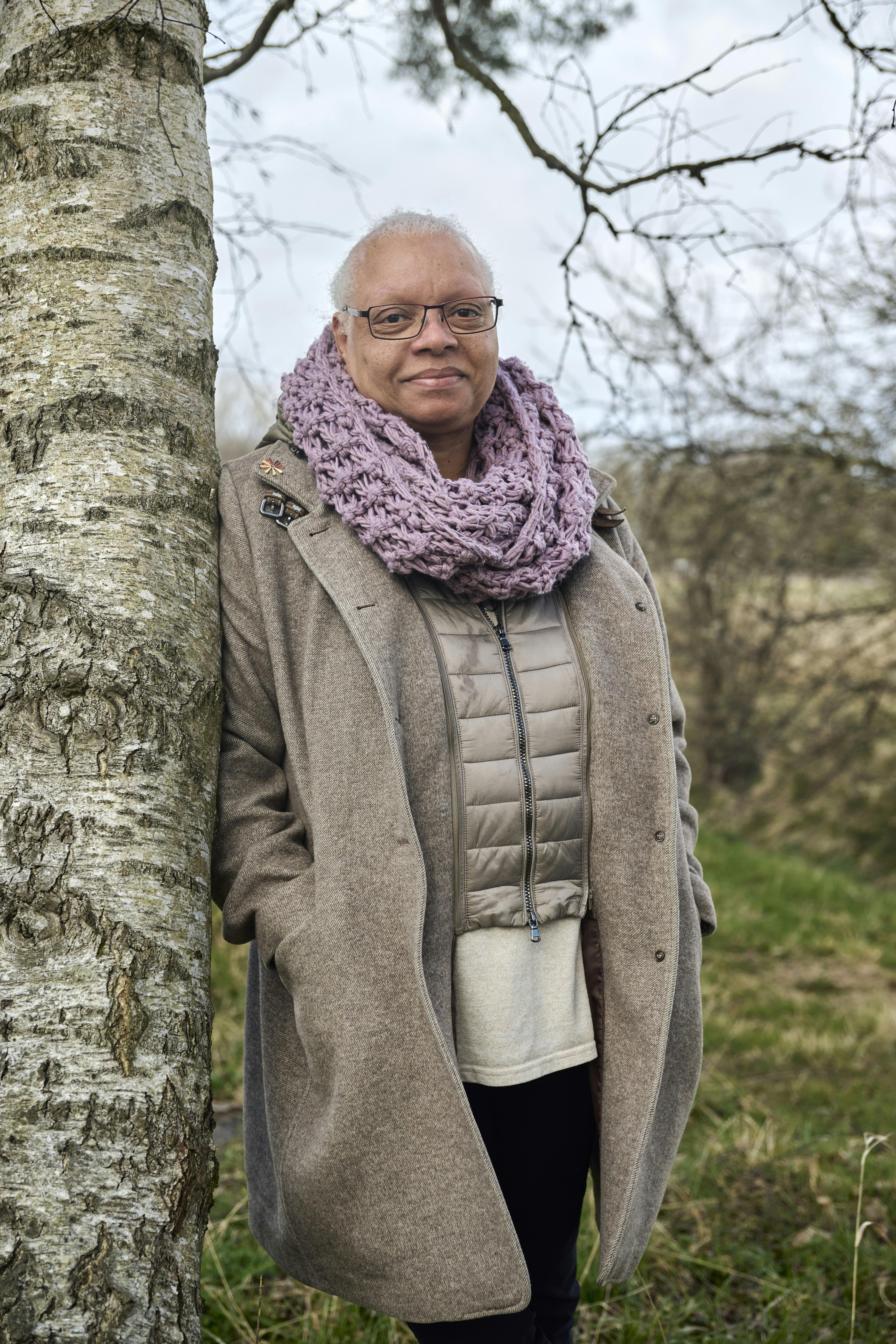 Gitte der står op af et træ.