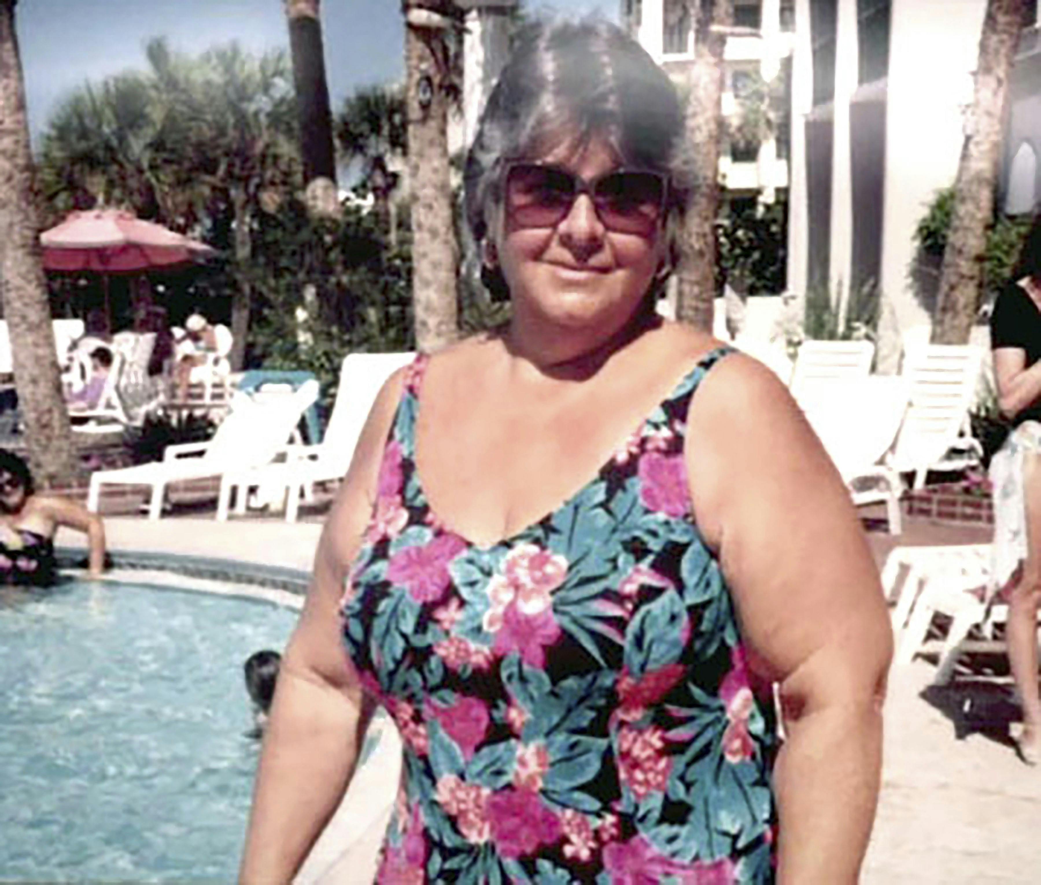 Beverly der står ved en pool i badedragt.