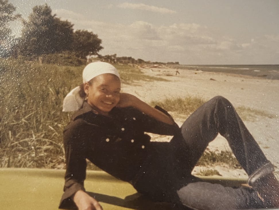 Et ældre billede af Gitte der ligger nede ved en strand. 
