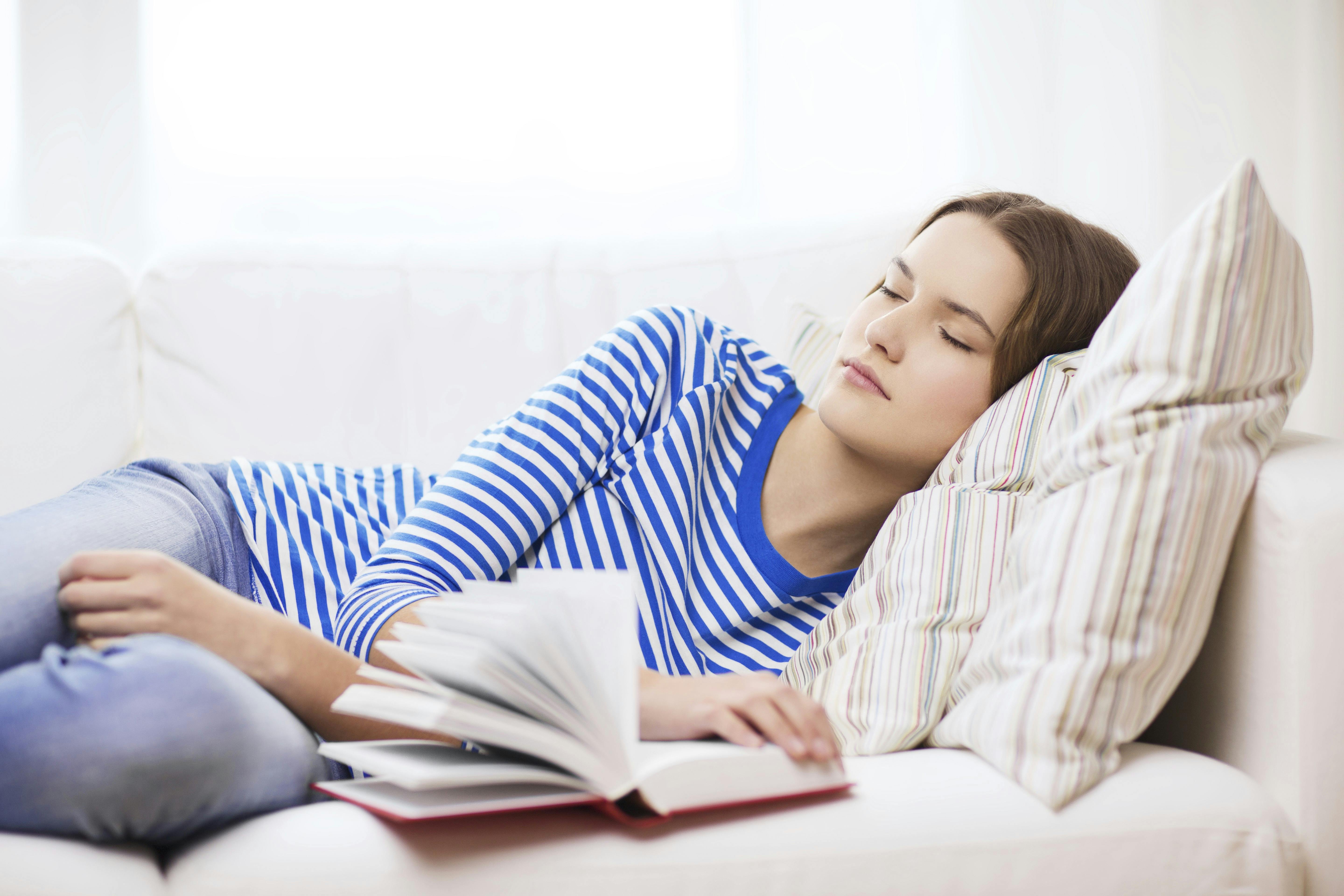 Kvinde sover på sofa.