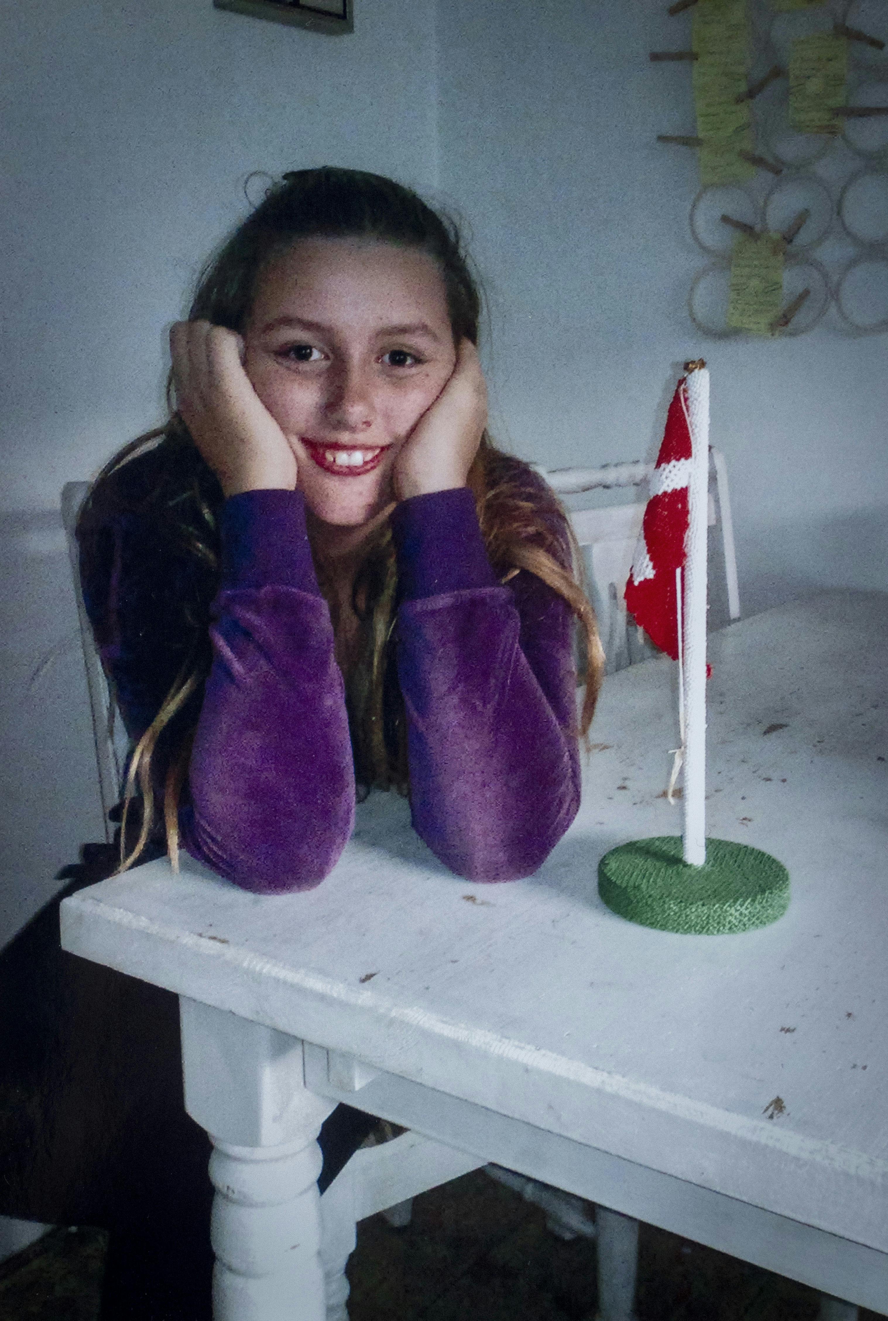 Emilie siom barn, hvor der står et fødselsdagsflag ved siden af hende. 