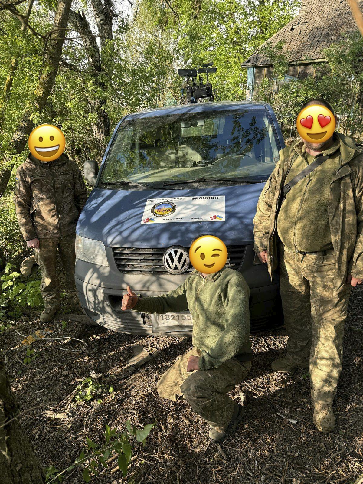 VW transporter med tre soldater foran bilen. 