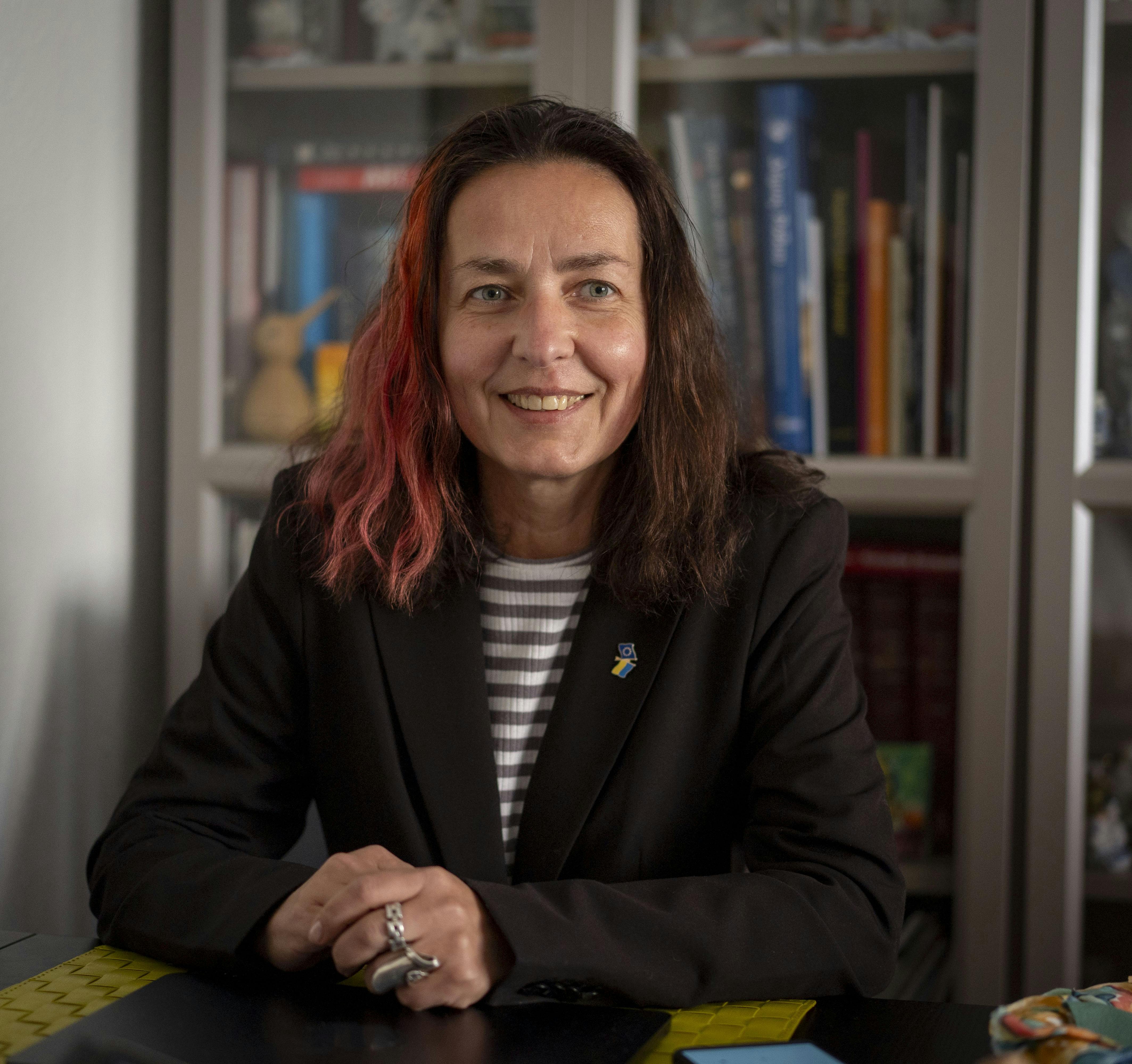 Helena Tomasson der sidder ved et skrivebord. 