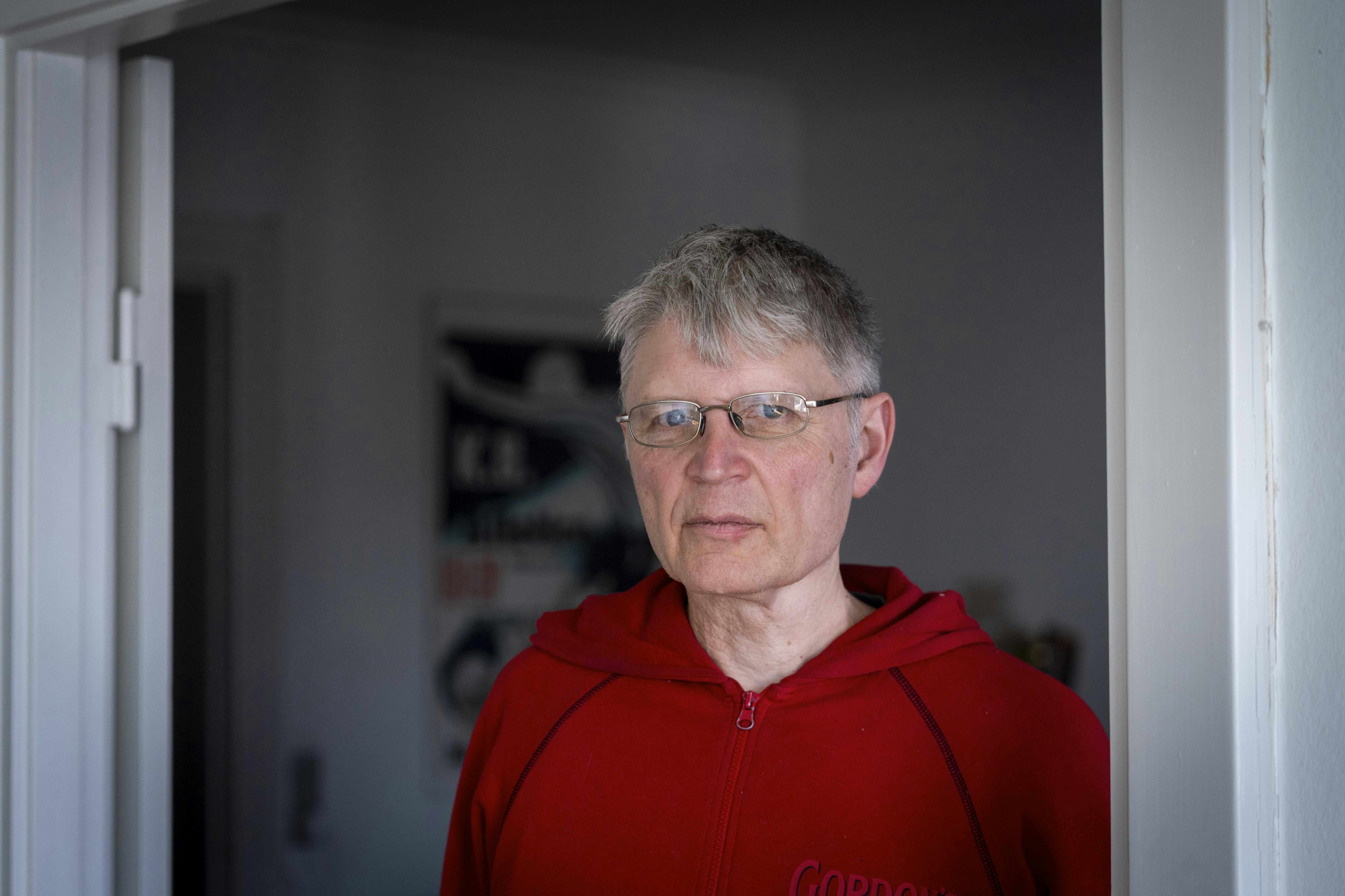 Hans der står indenfor i en rød trøje. 