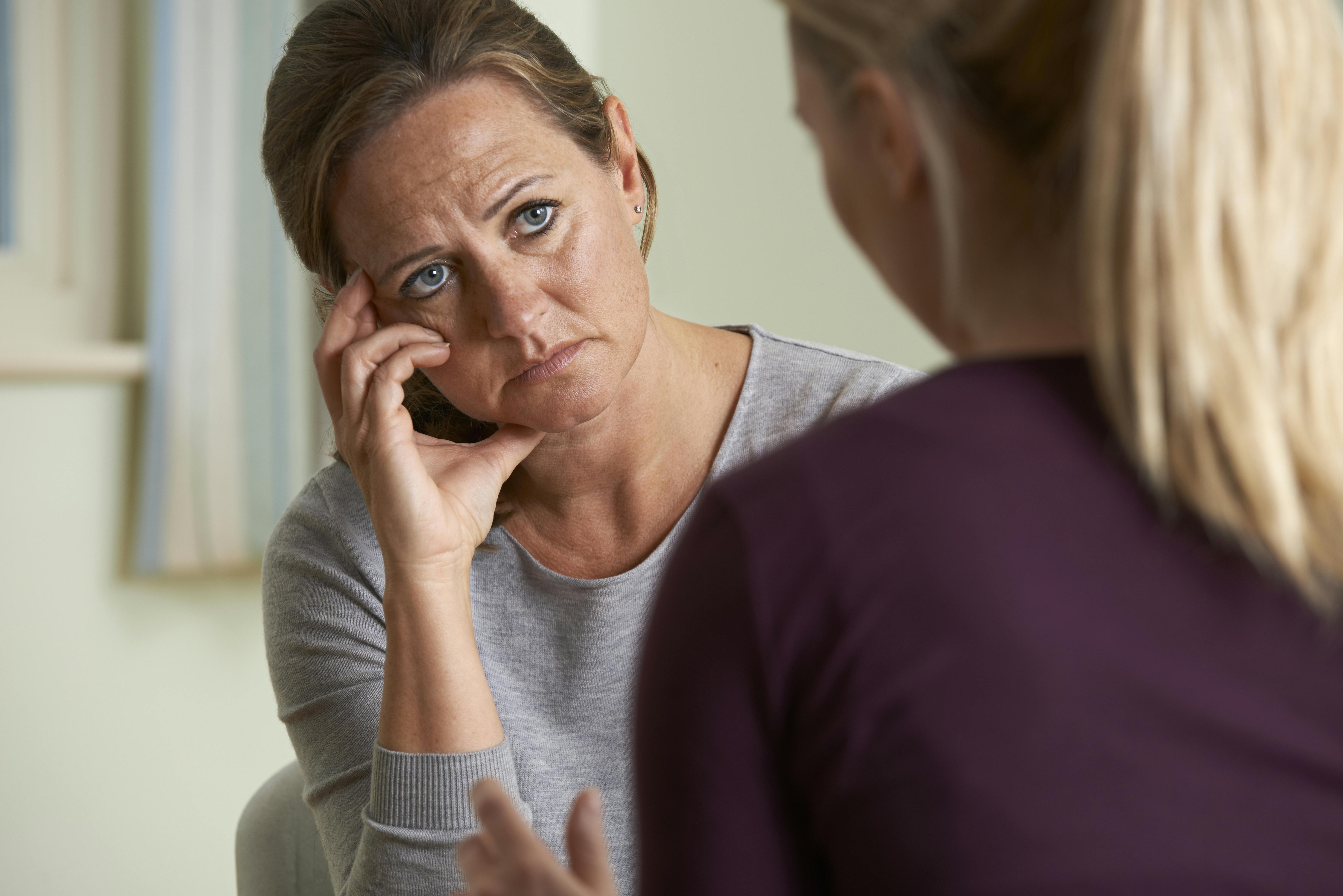 Svigermor ser opgivende ud, mens hendes svigerdatter taler til hende.