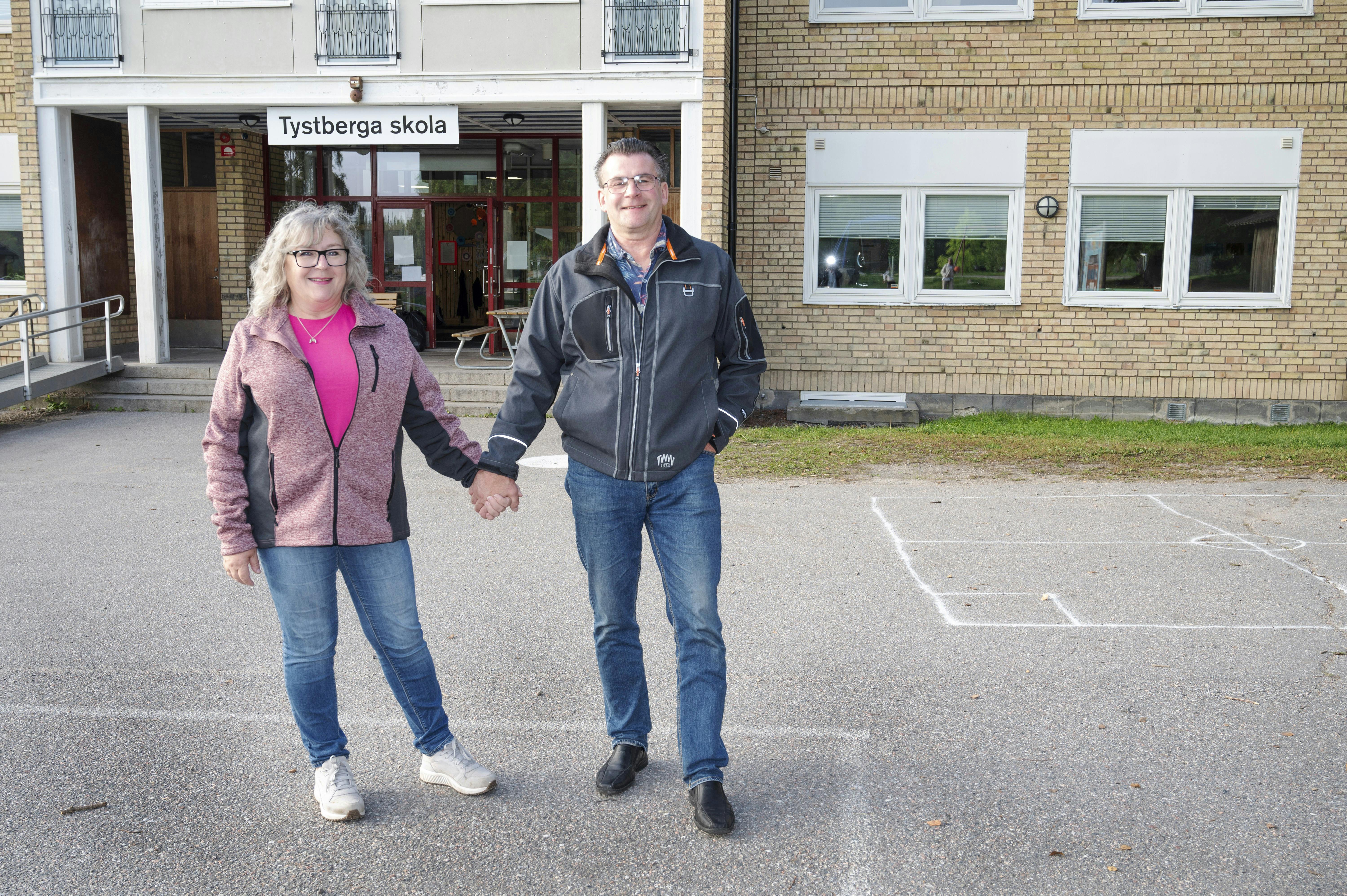 Gun og Roger, der holder hinanden i hånden foran Tystberga skole. 
