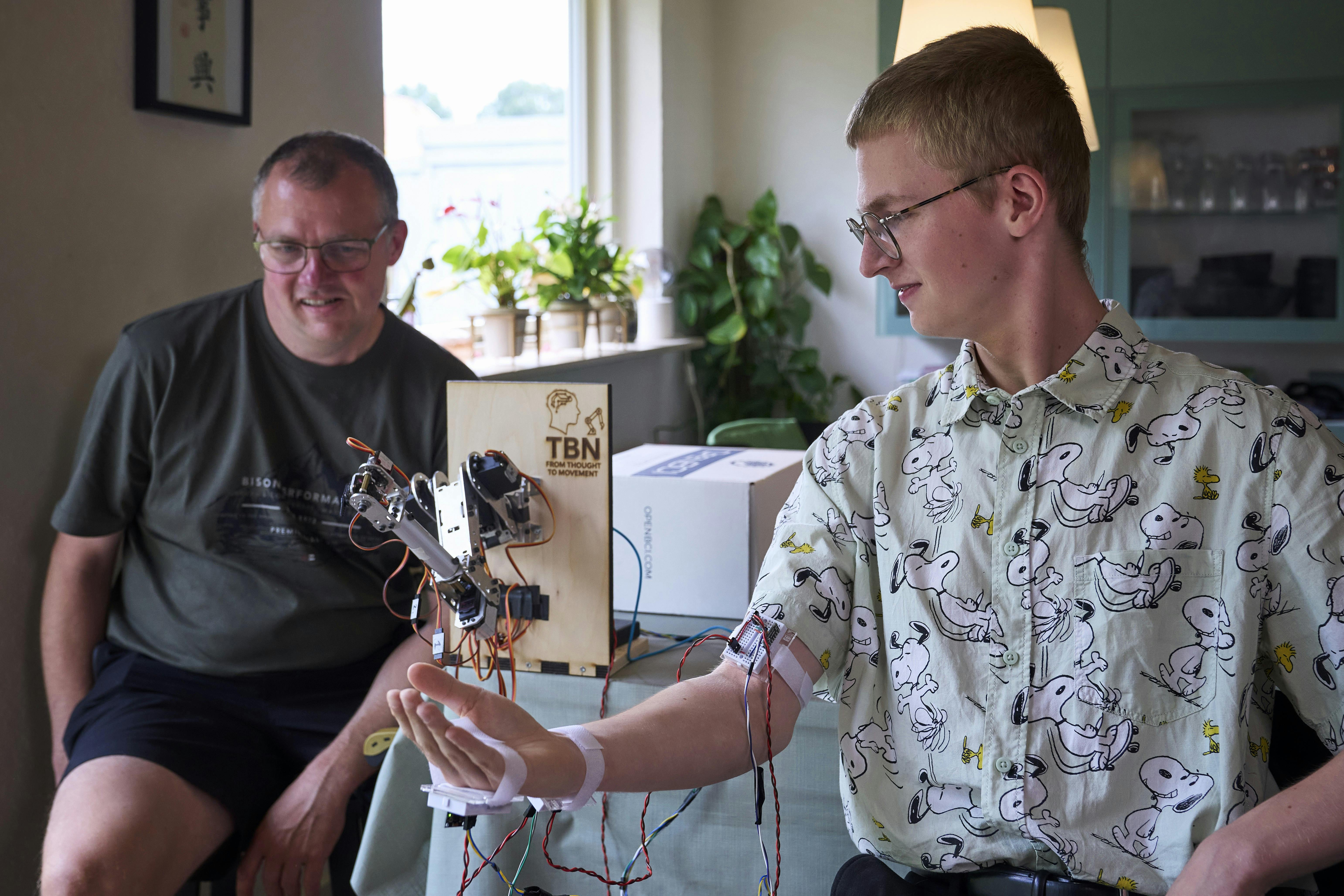 Tobias Bendix Nielsenog hans far, der kigger på robotarmen. 
