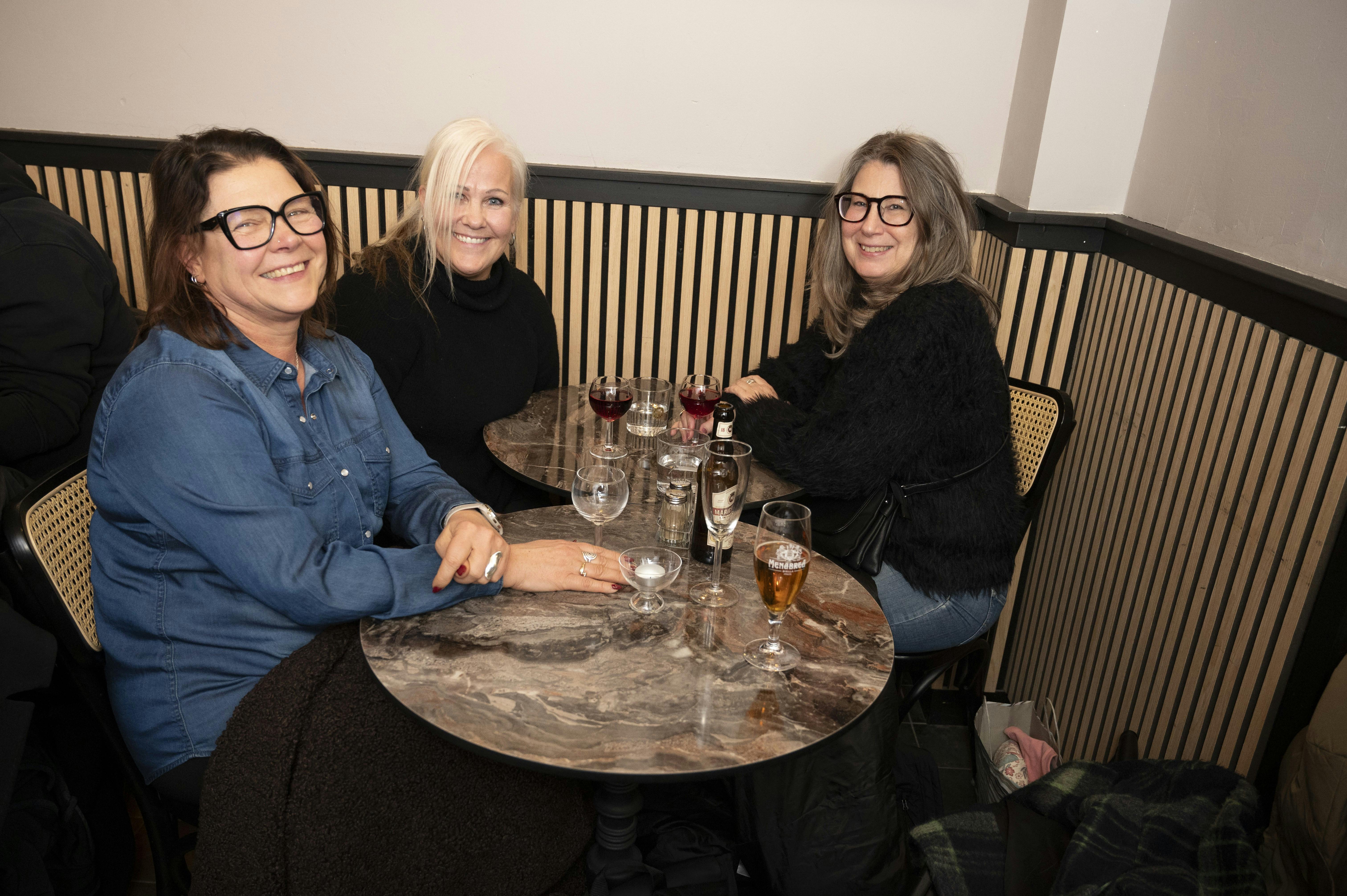 Veninderne Carina, Lena og Jonna, der sidder ved et bord. 