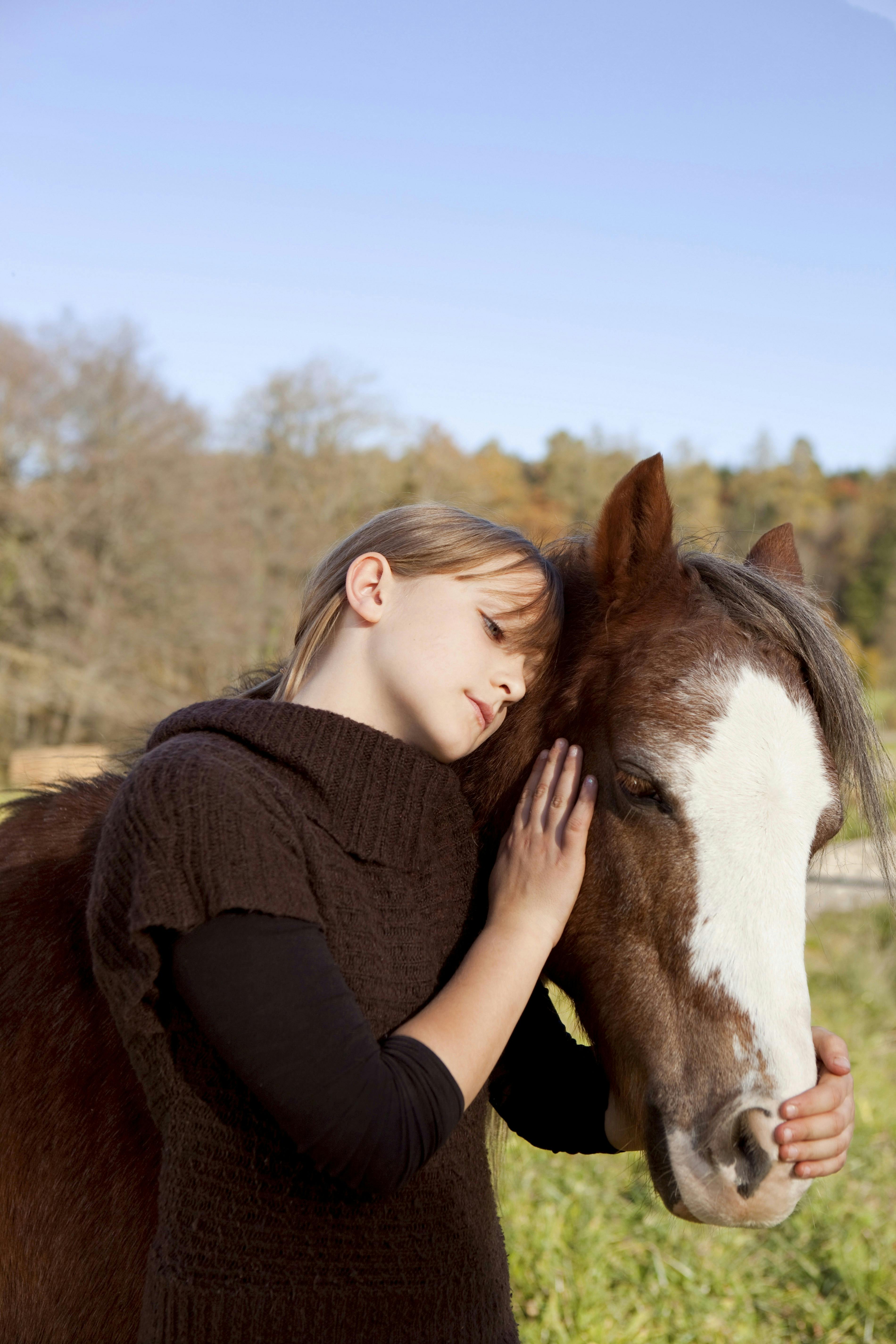 Pige står sammen med en hest