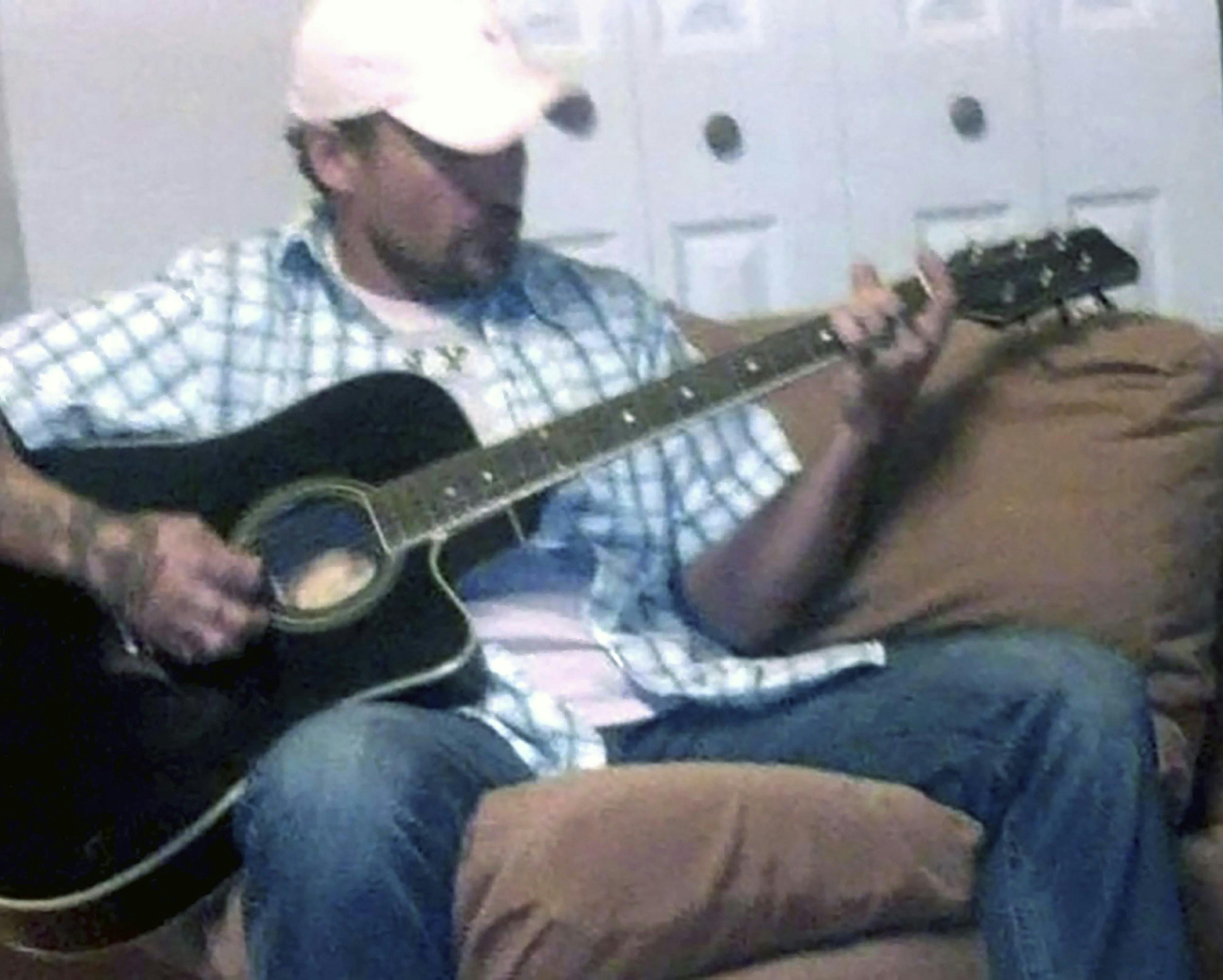 Brent med en guitar