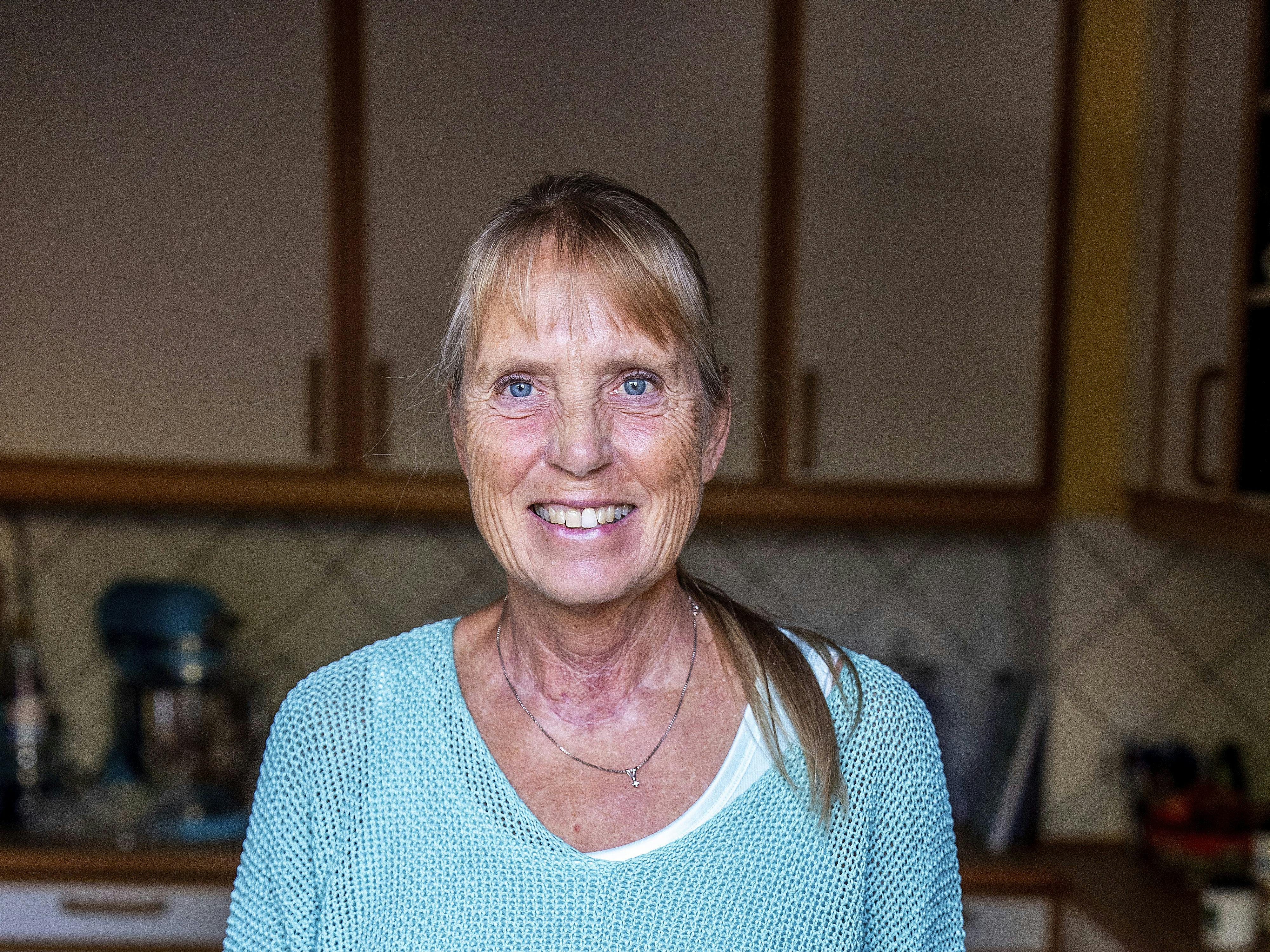 Britta Nielsen står i sit køkken med sunde grøntsager på køkkenbordet.