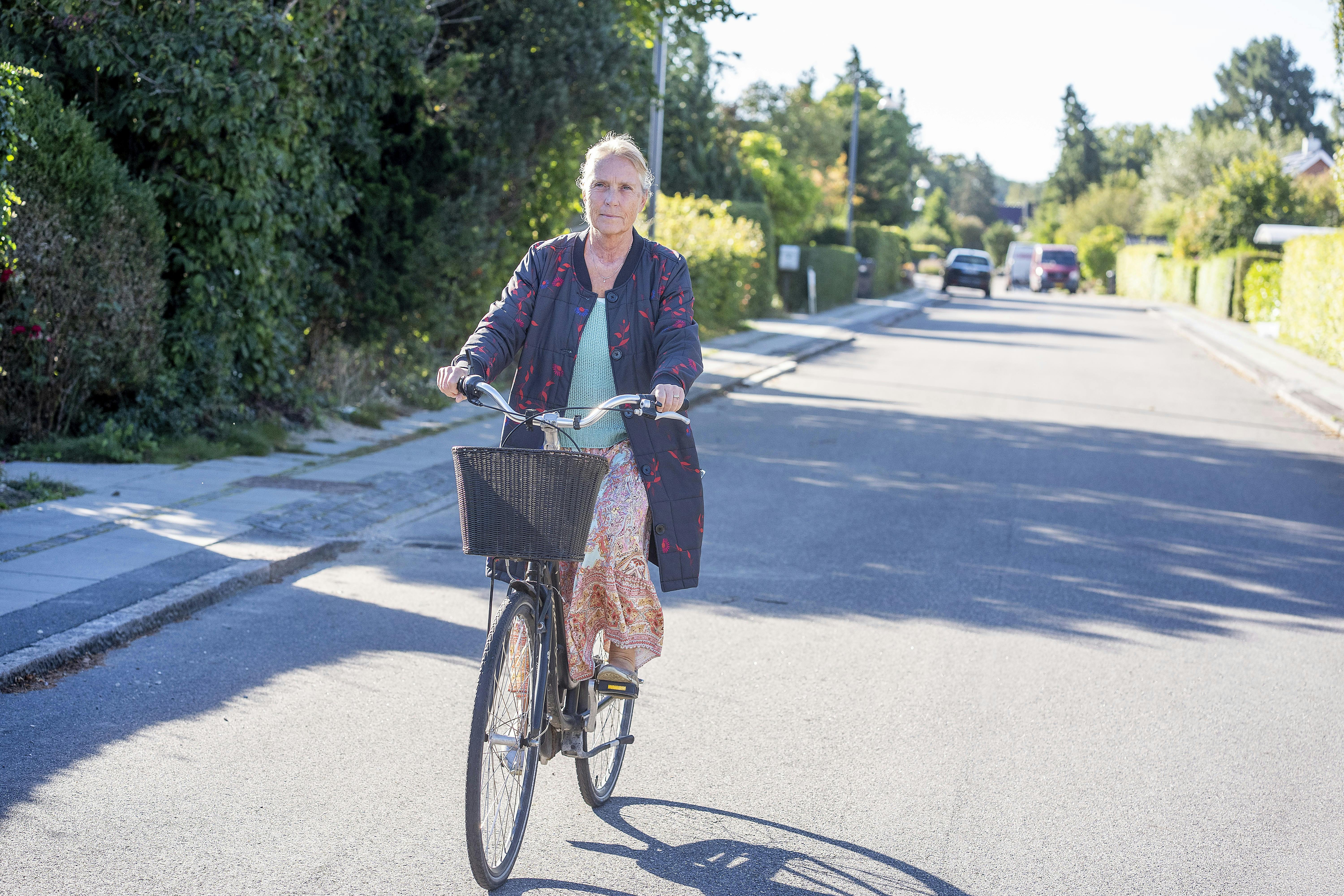 Britta Nielsen cykler på en stille villavej i nabolaget.