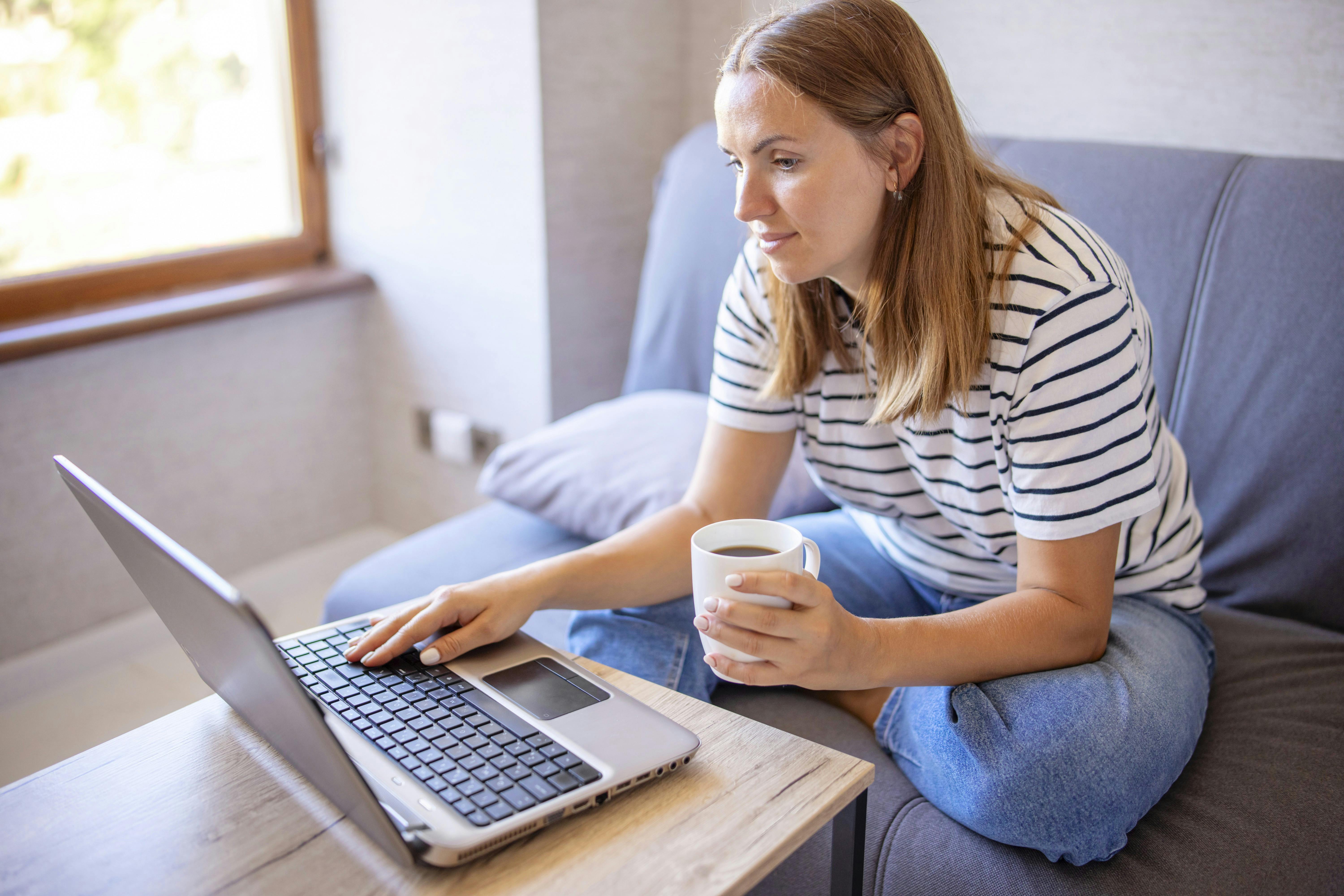 Kvinde, der sidder med sin computer.