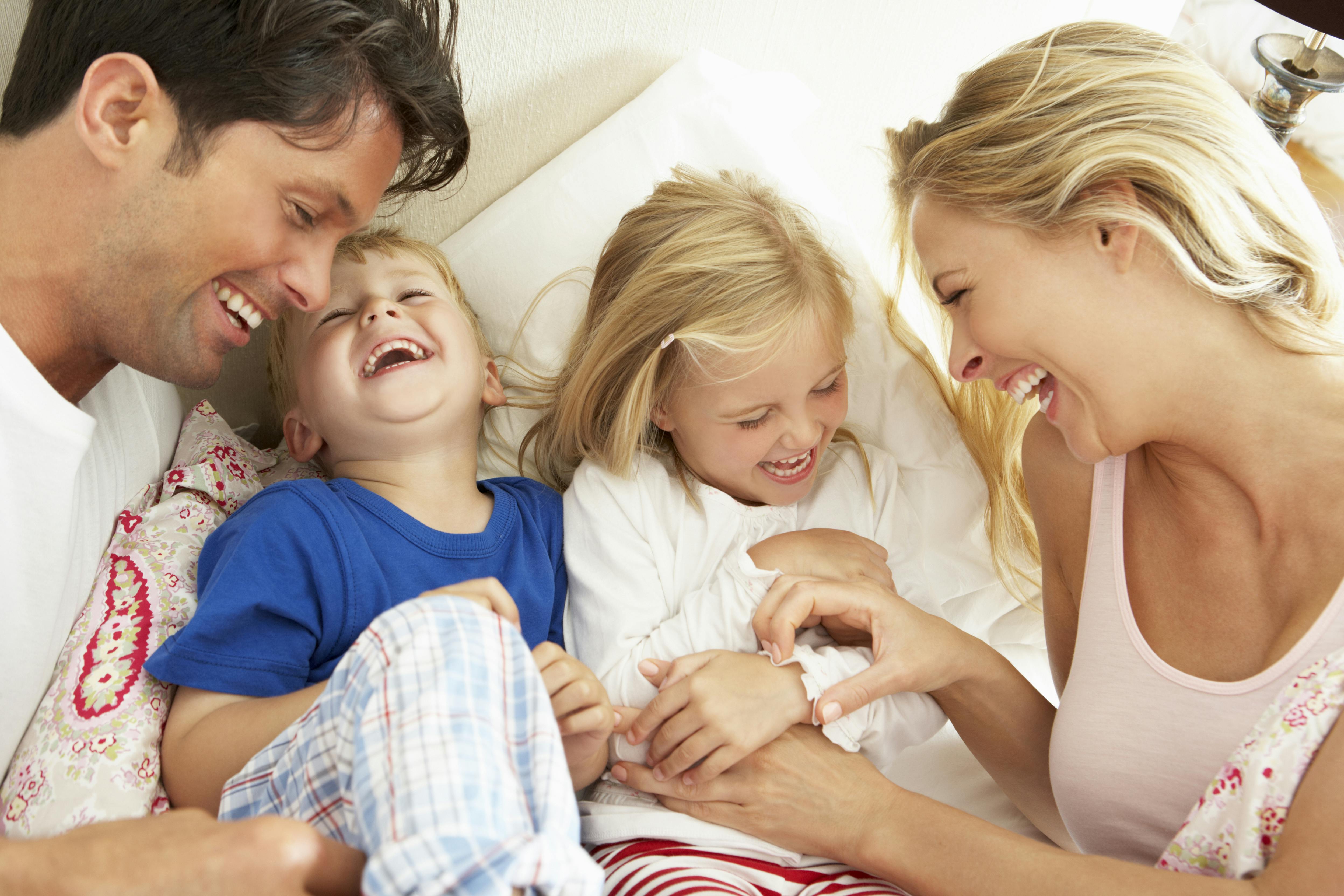 Liv og livslyst: Familie med far, mor og børn griner og fjoller sammen for at illustrere livslyst og glæde