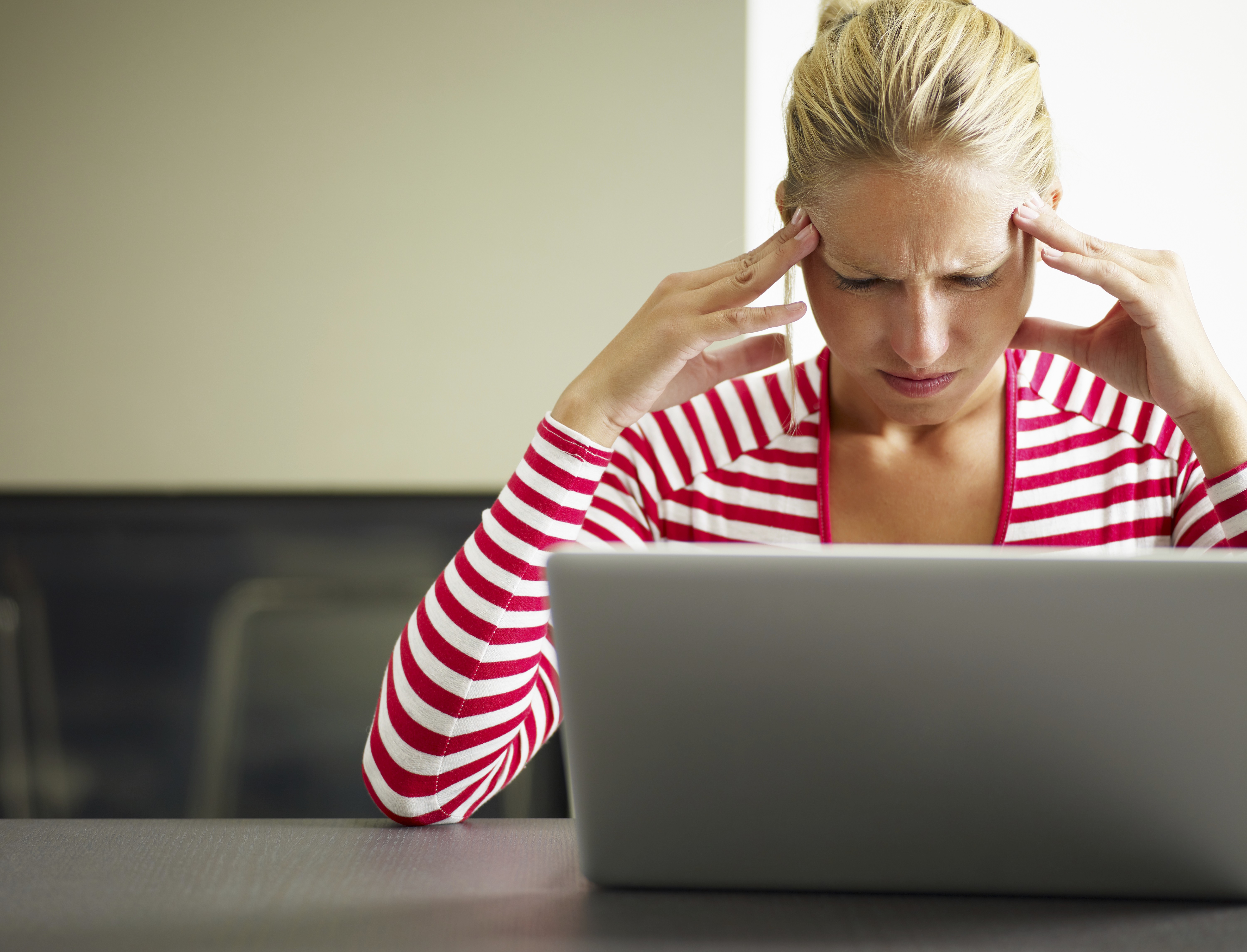 Pas på skjulte abonnementer, når du handler online: Frustreret kvinde sidder og kigger ned på sin computerskærm