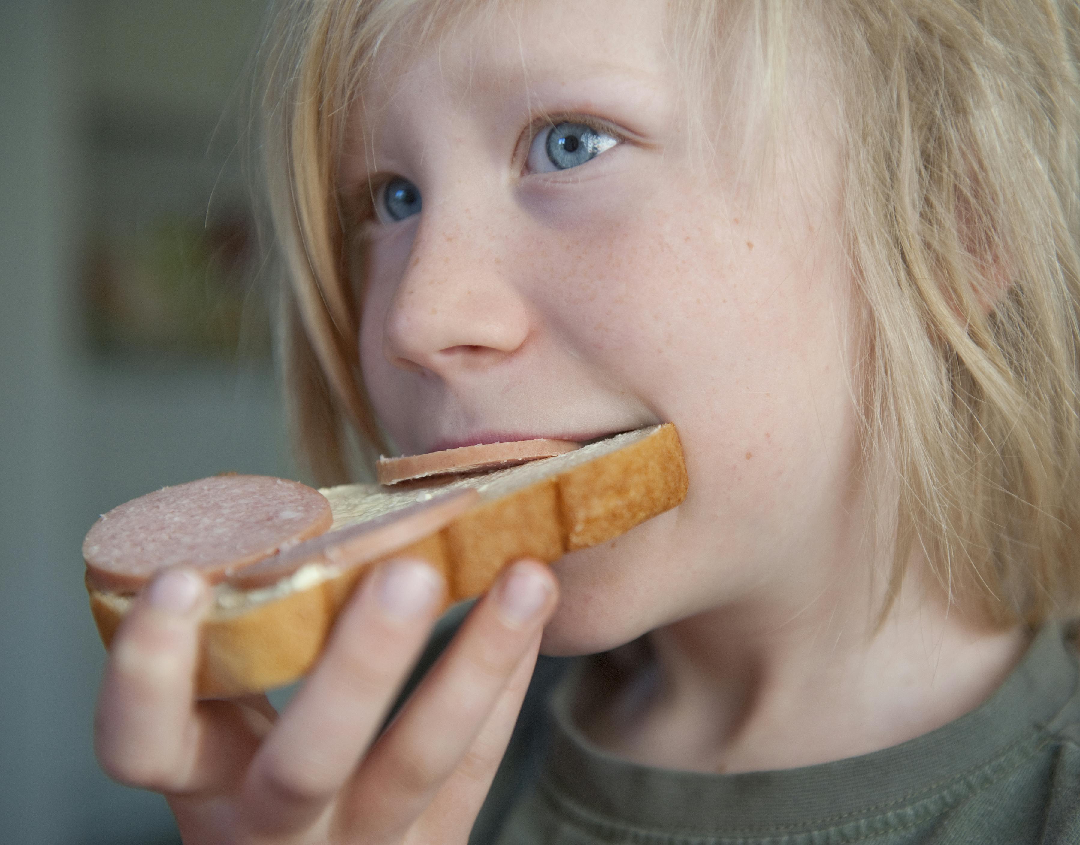Vegetar: En 5-årig dreng spiser en franskbrødsmad med spegepølse.