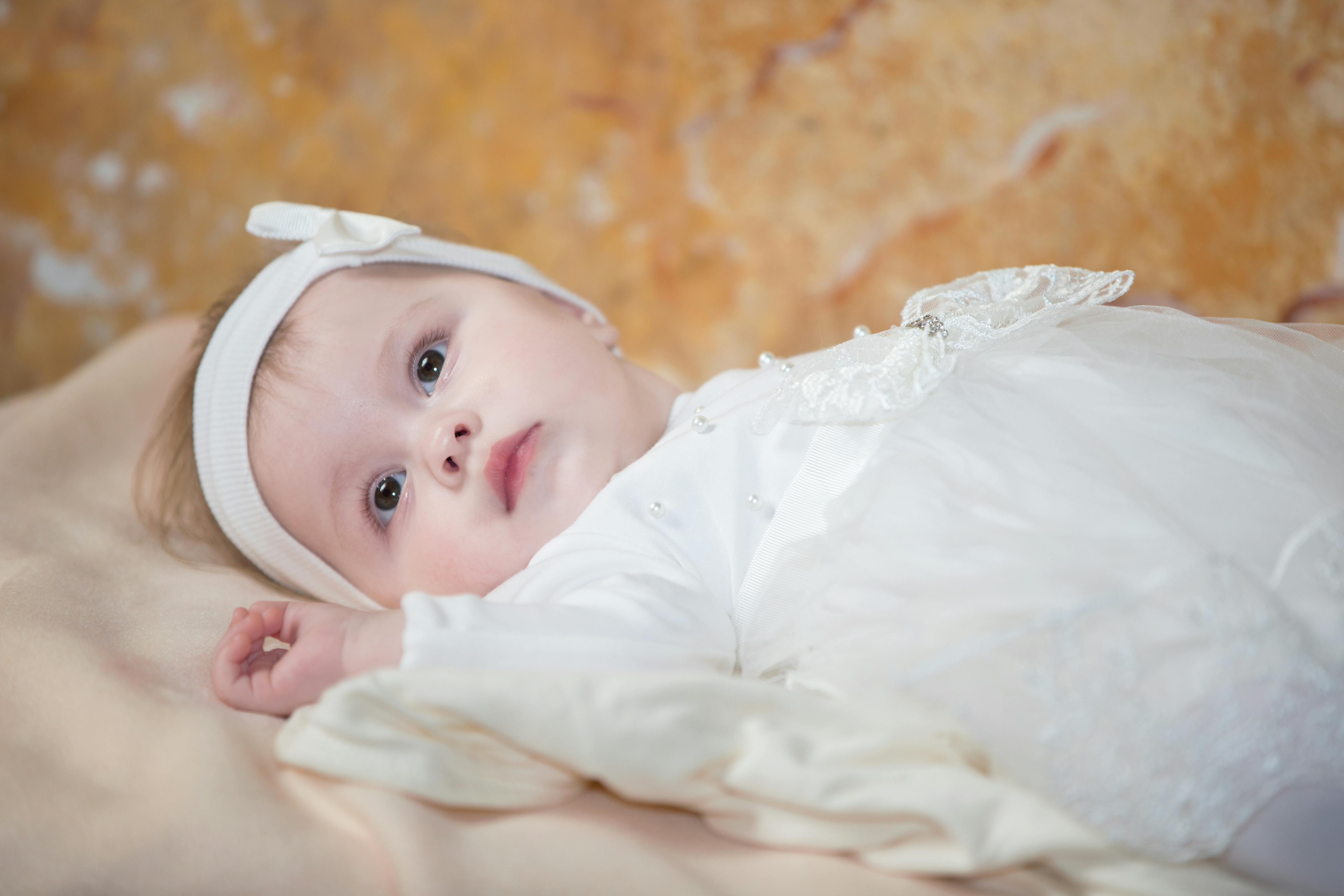 Dåbskjolen er gul af nikotin. Baby i dåbskjole.