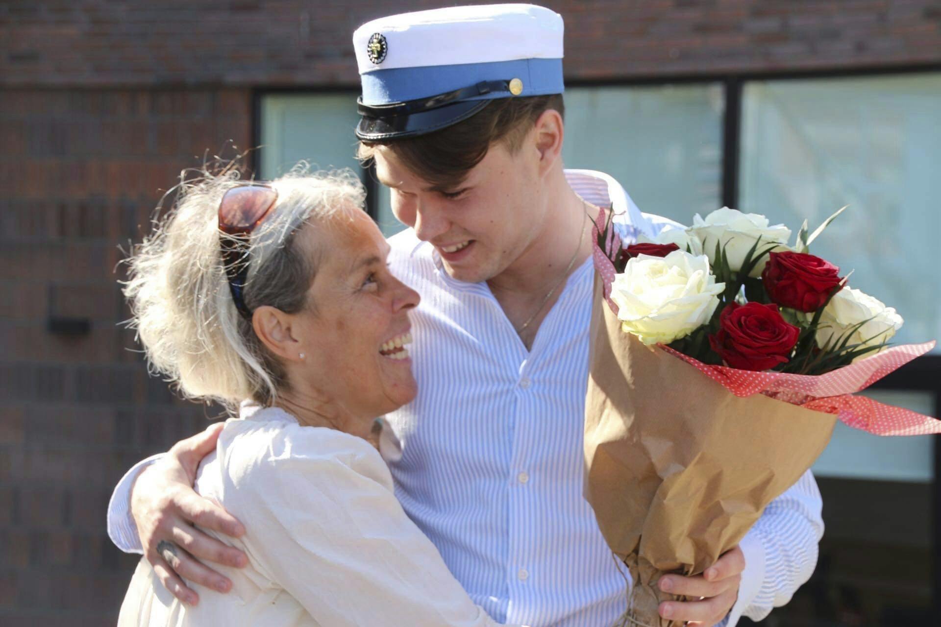 Anton Dinesen med hue og blomster og med mor