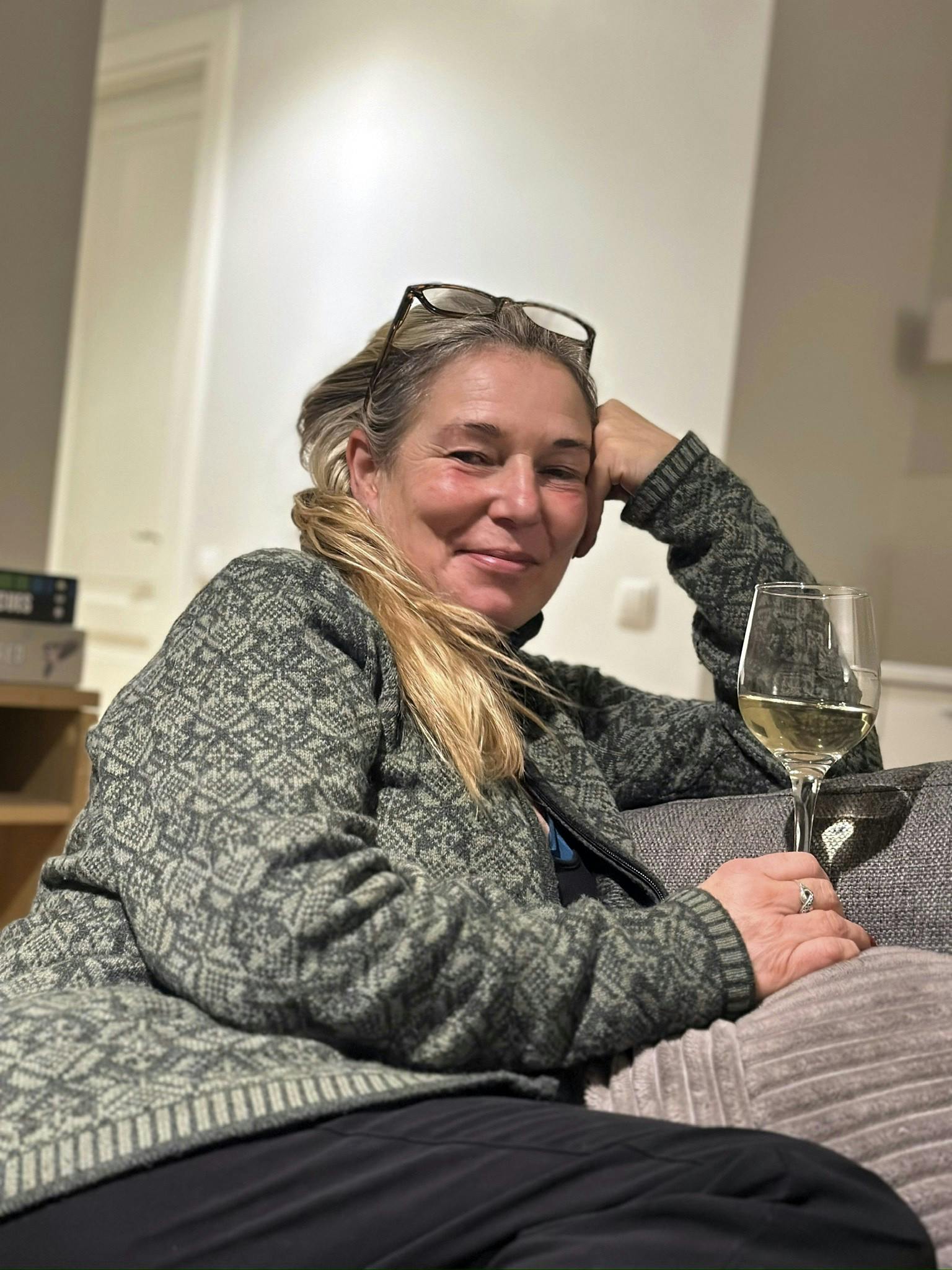 Et privat foto af Inge Metere, der nyder et glas vin i en sofa.