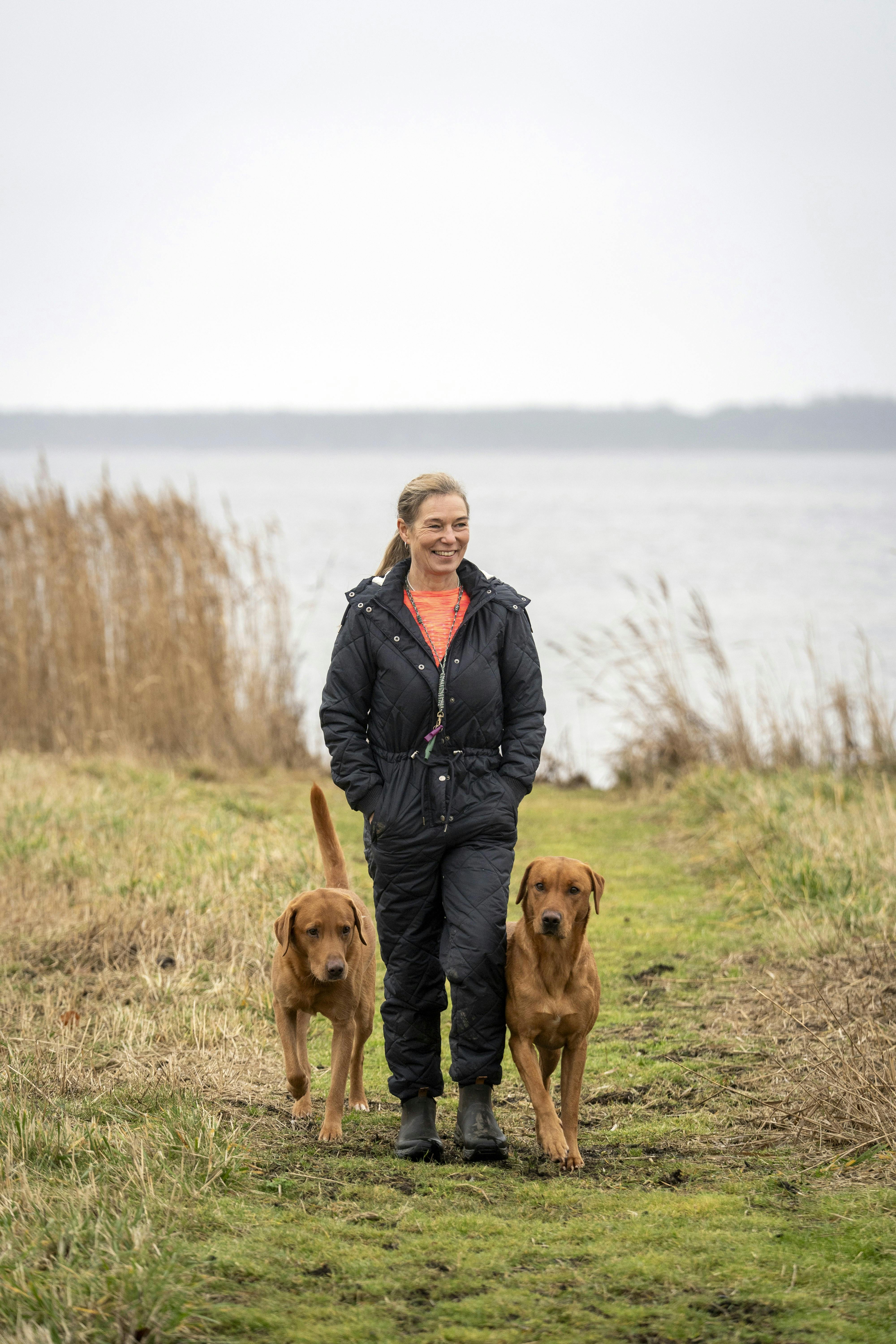 Inge Merete går tur med sine to hunde langs vandet tæt på hjemmet i Tappernøje.