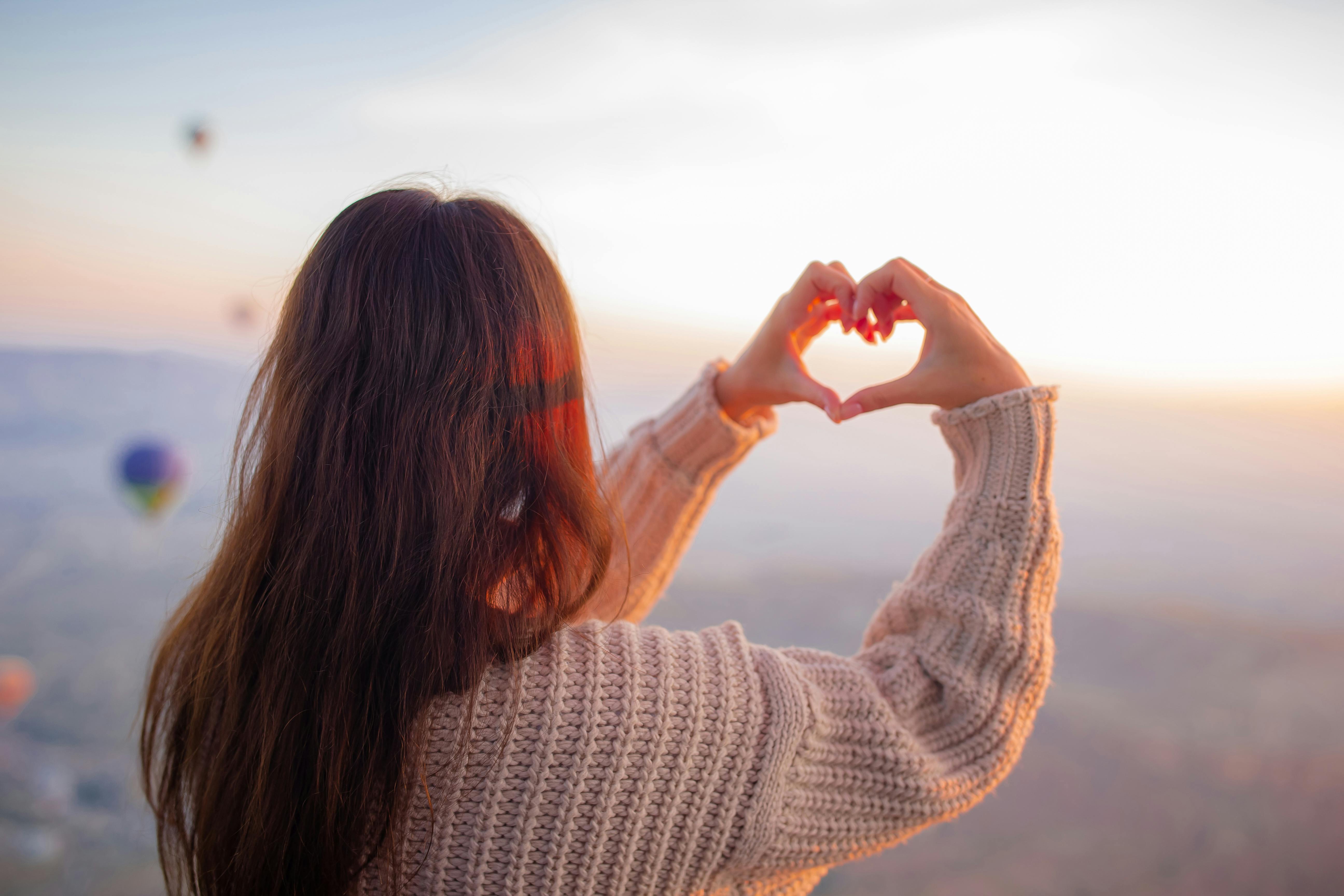 Tegn fra det hinsides: Mor viser sig for mig i skyerne - Kvinde laver hjerte med hænderne op mod himlen