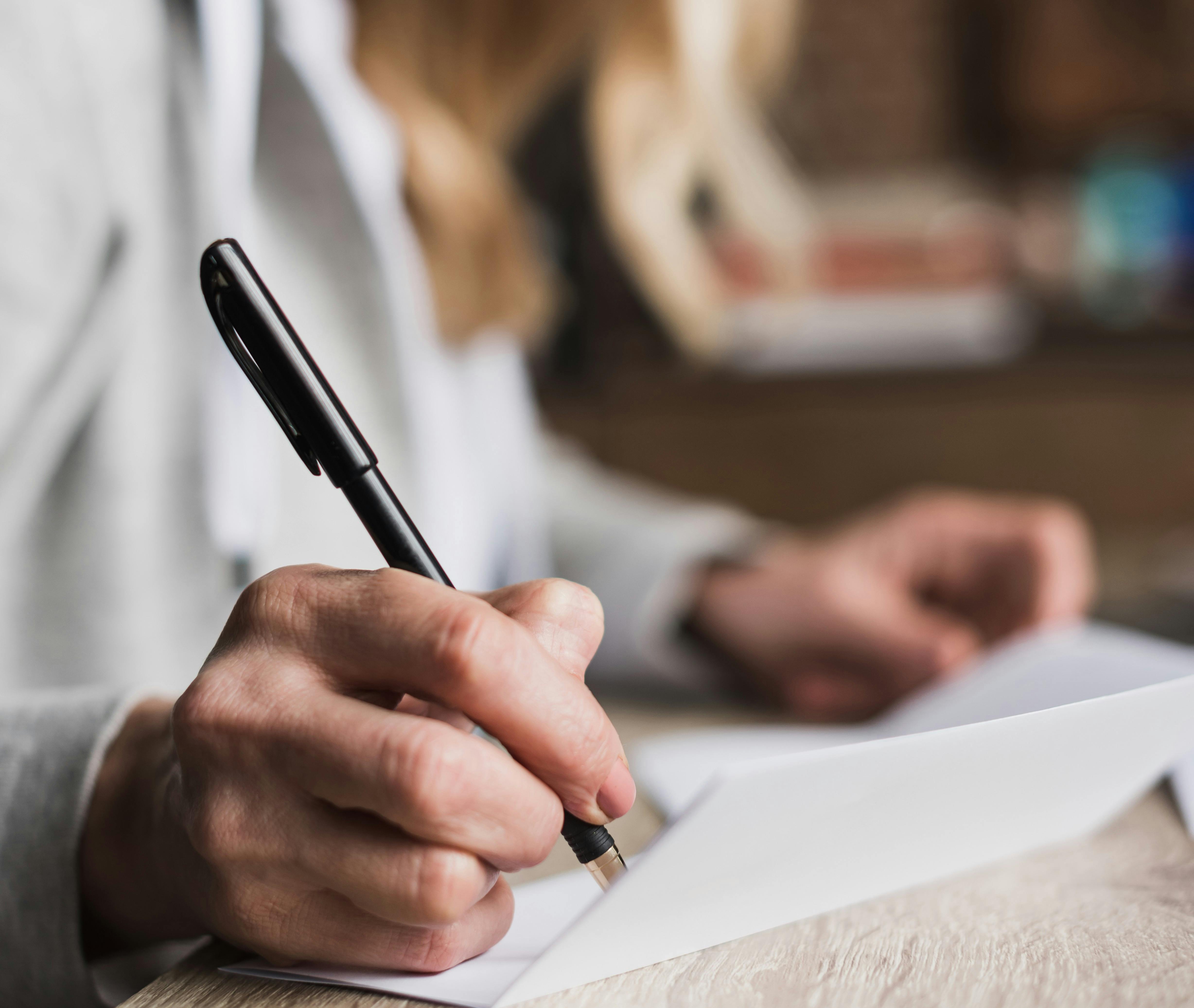 Arvesager: En kvinde er ved at skrive på et dokument.