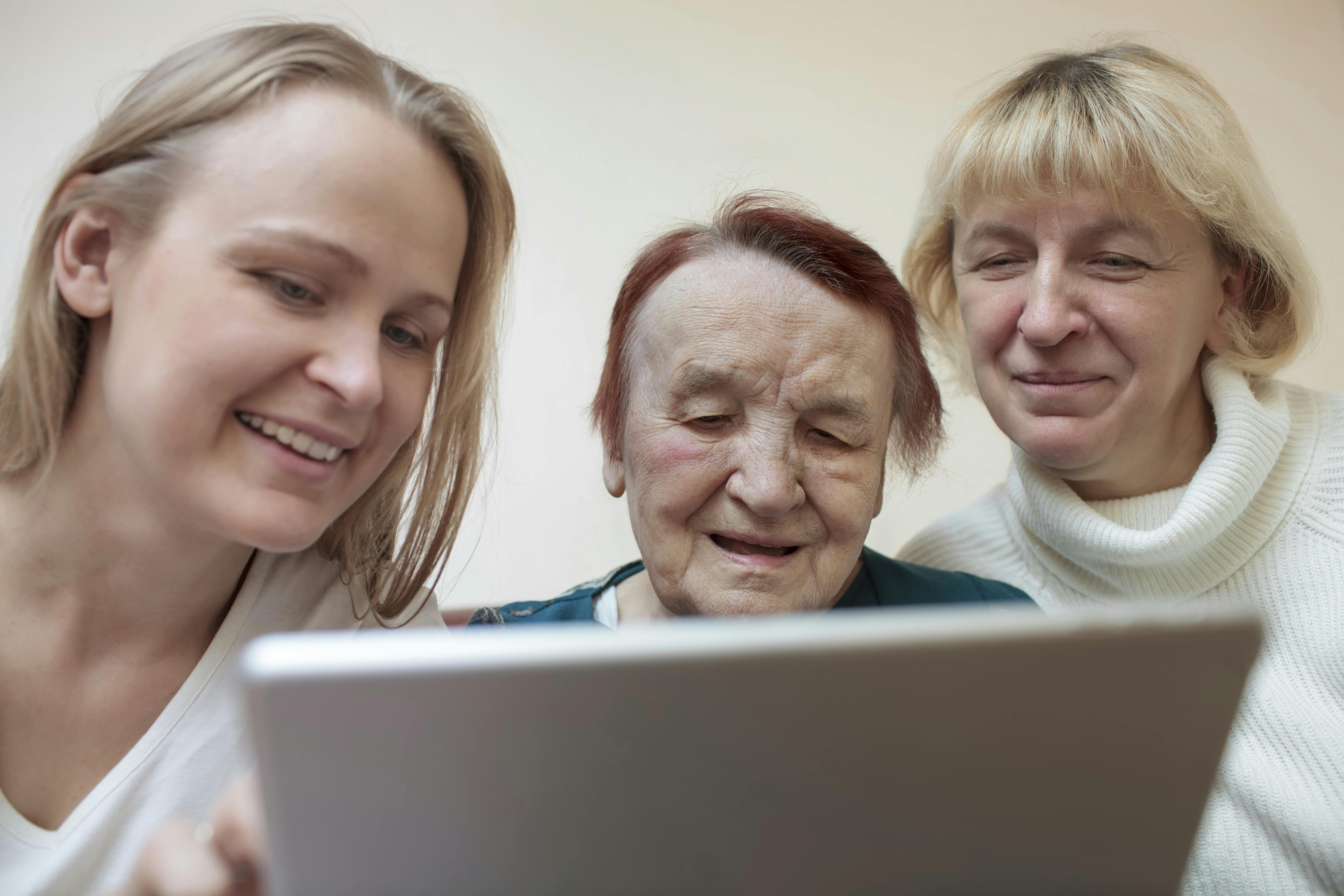 Ny fuldmagt skal gøre det lettere at hjælpe andre: Tre kvinder sidder rundt om en bærbar computer