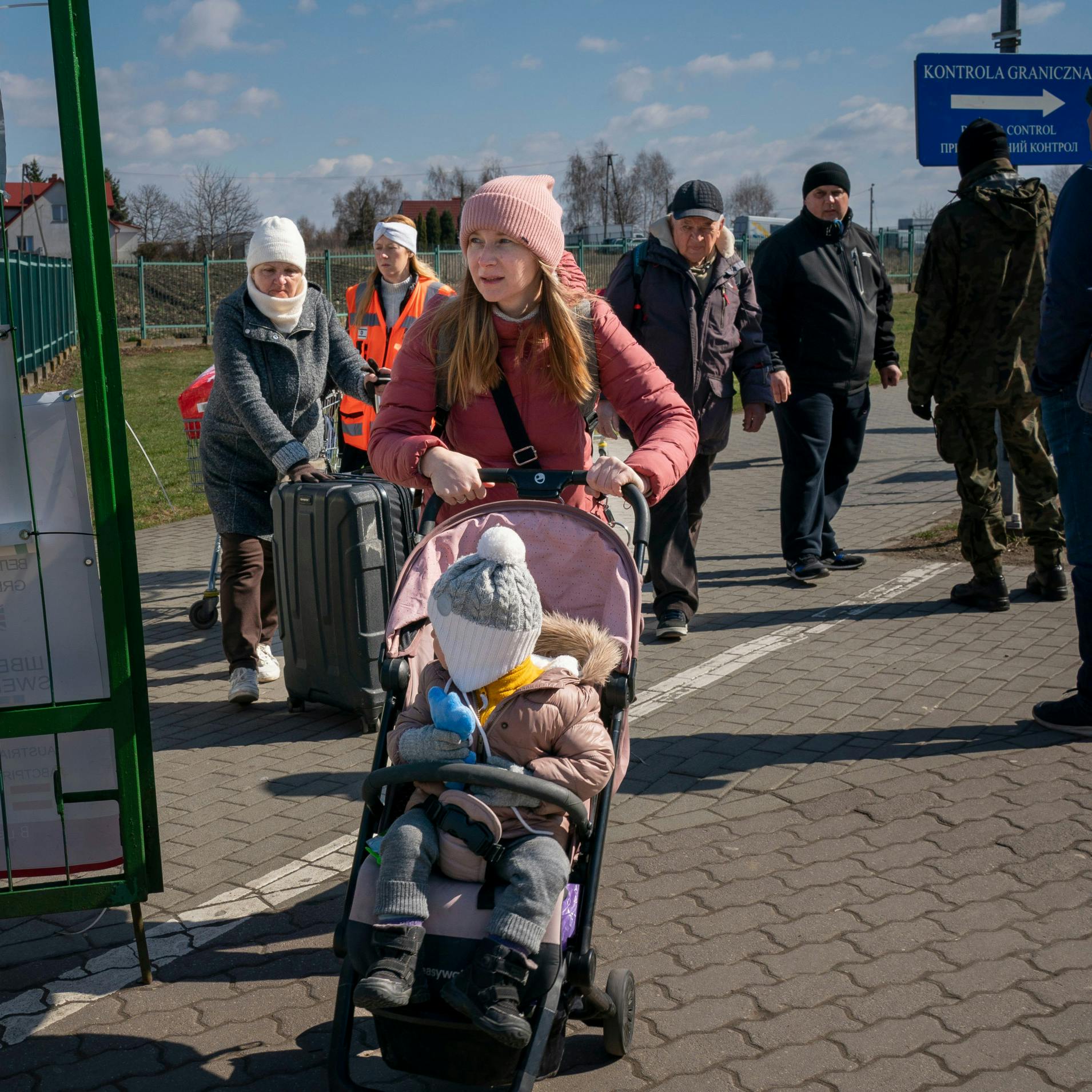 Olga og Polina går gennem den grønne låge, der markerer grænsen mellem Ukraine og Polen.
