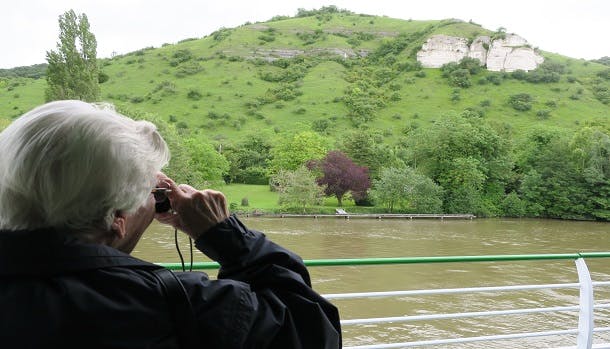 På dækket har andre rejsedeltagere travlt med at fotografere Normandiets grønne landskaber.