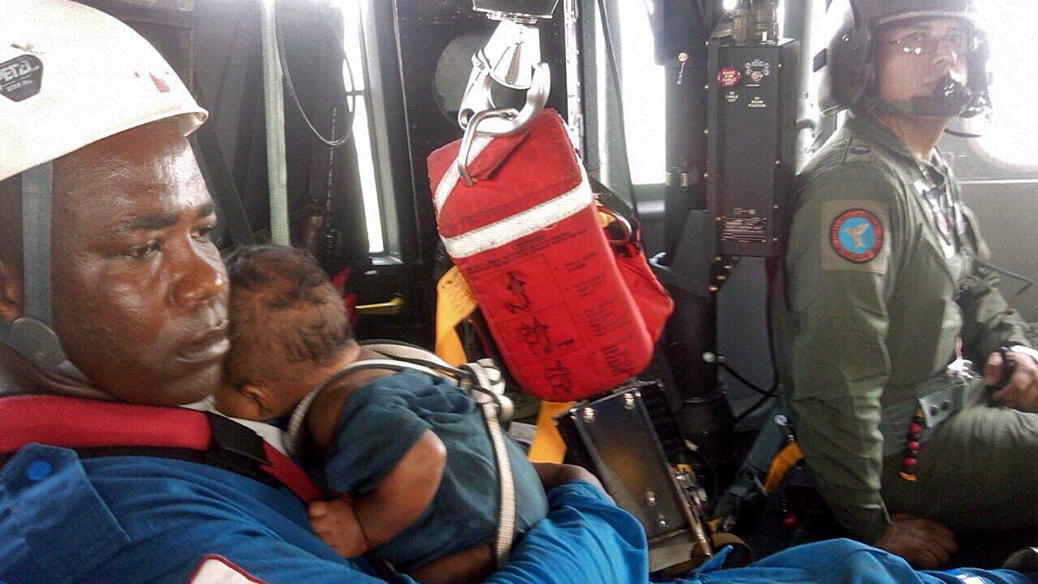 Redningsfolk beskriver det som et mirakel, at mor og barn overlevede. Her er det en Røde Kors-medarbejder, der har fået babyen i sikkerhed. &nbsp;