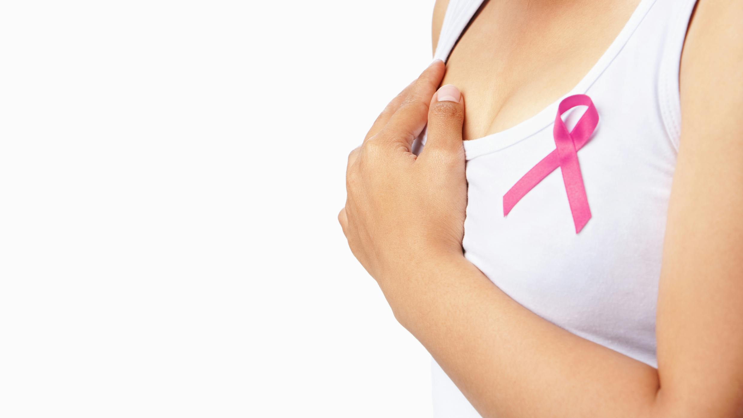 Kvinde har en sløjfe på blusen, som symboliserer brystkræft