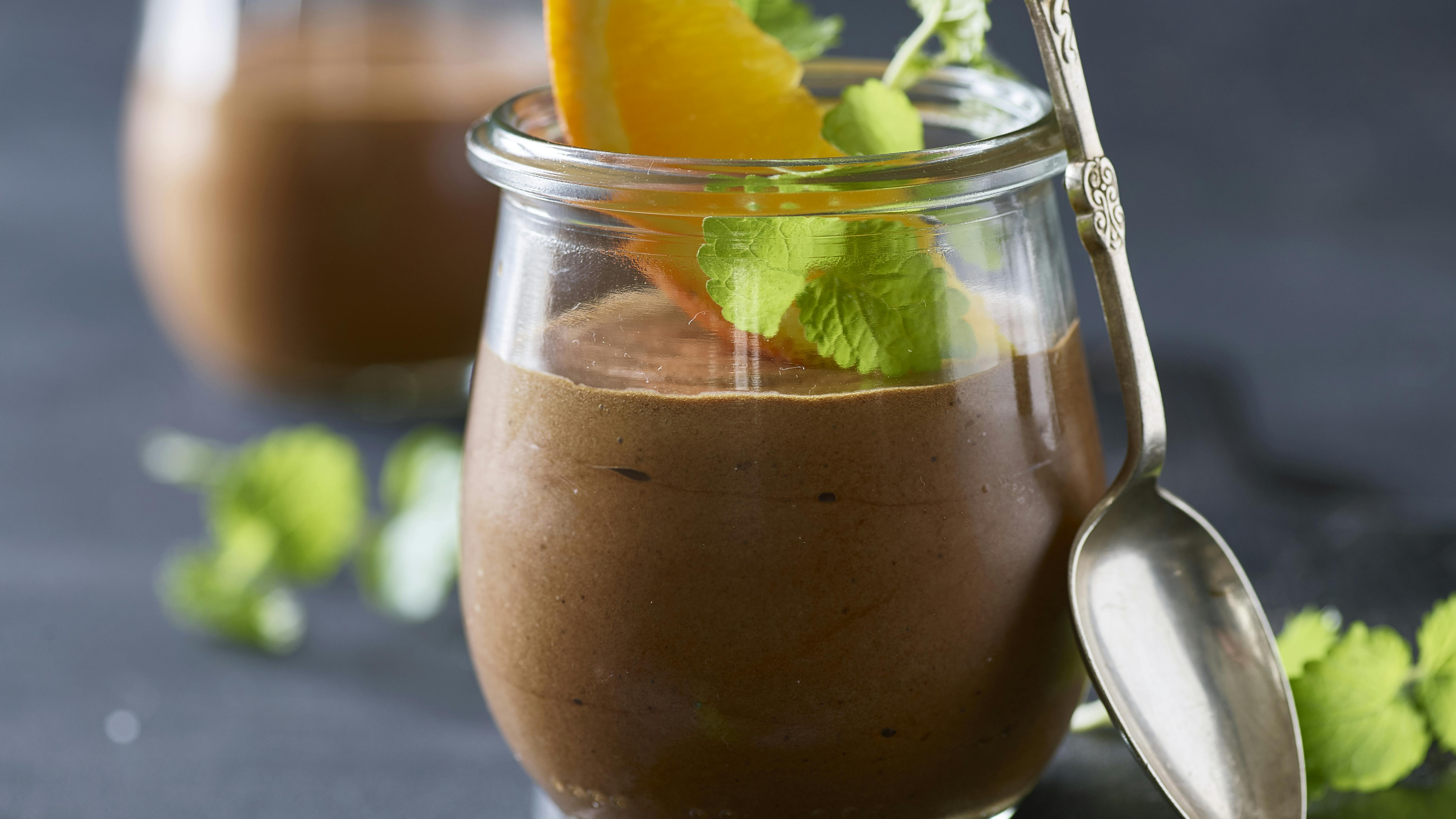 Chokolademousse serveret i glas pyntet med appelsinbåde