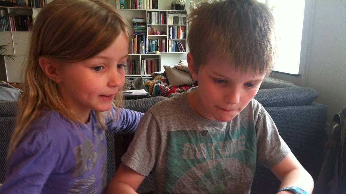 Dreng og pige på cirka syv-otte år sidder sammen ved en computer