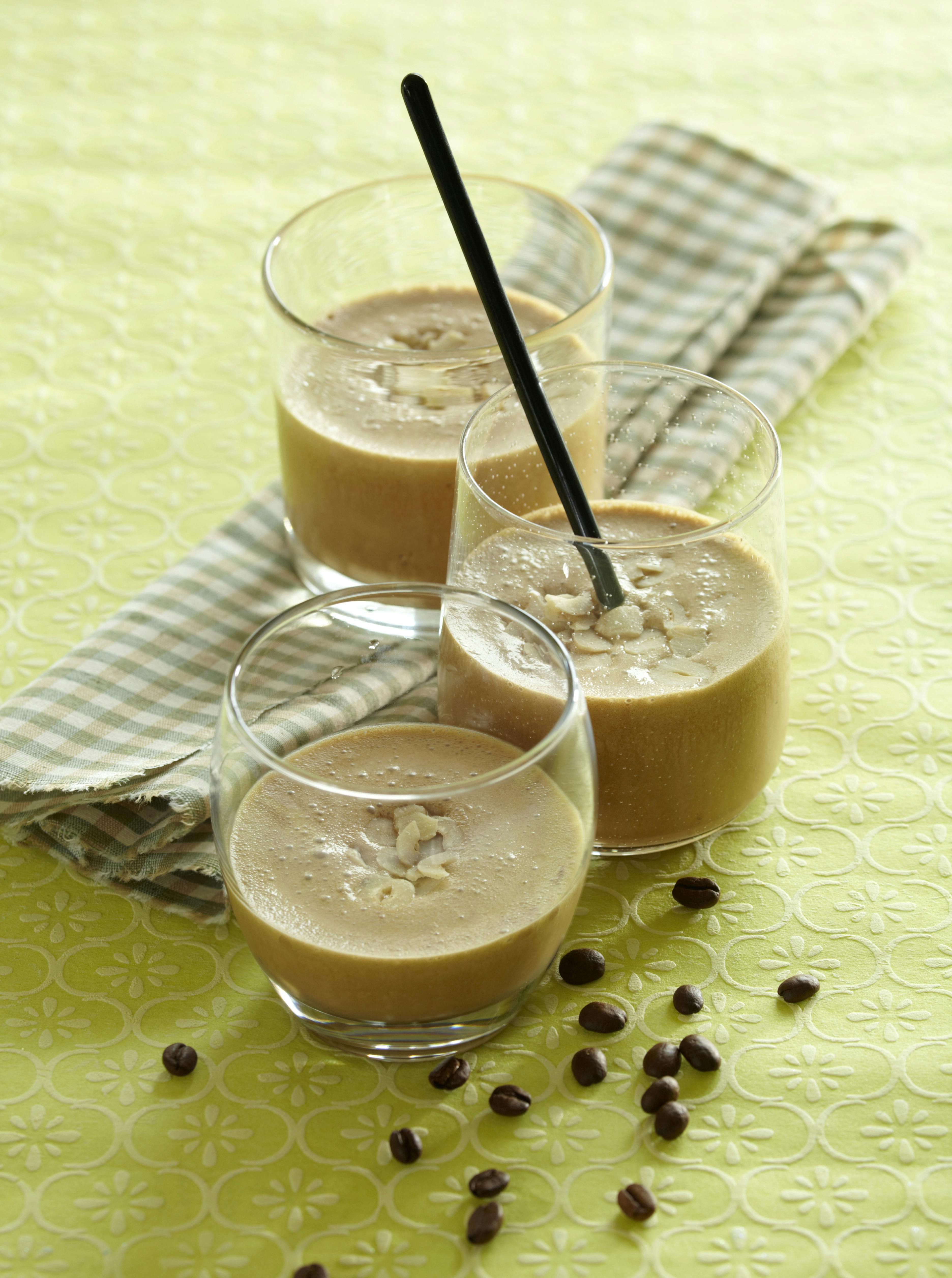 Høje glas med en iskaffe tilsat vanilje-is, isterninger og chokoladesauce.