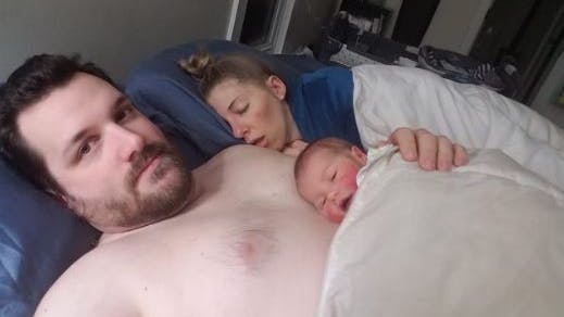 Far med baby og sovende mor ved siden