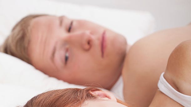 En mand og en kvinde ligger i sengen