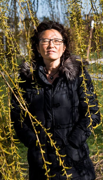 Kvinde står ved et træ med gule blade