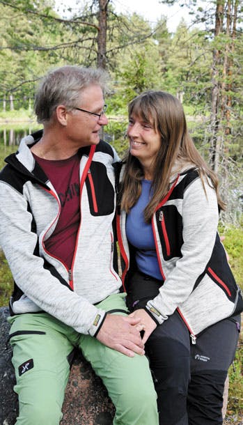 Mand og dame sidder på en stor sten i naturen