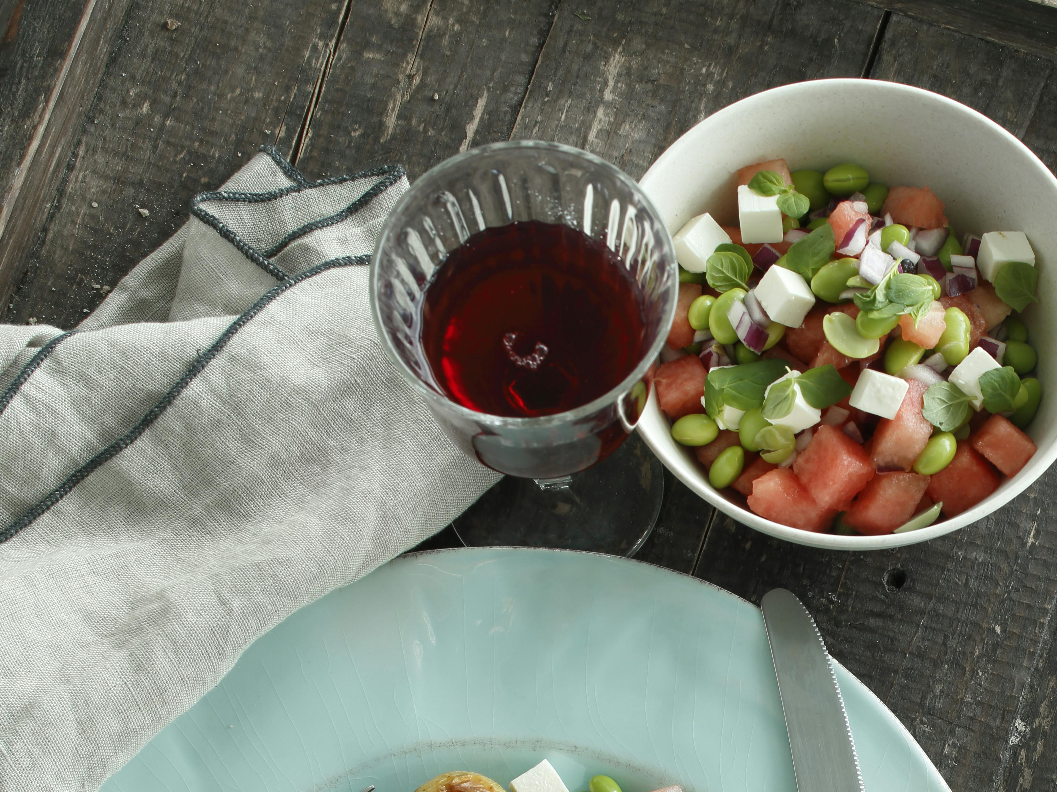 Skiveskåret svinemørbrad, der ledsages af rosmarinstegte kartofler og salat med edamamebønner og vandmelon