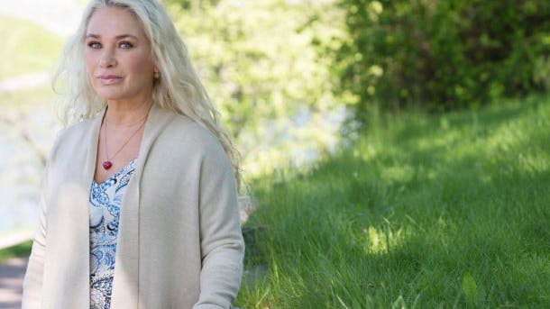 Dame sidder på græs. Har mistet sin søn på Utøya